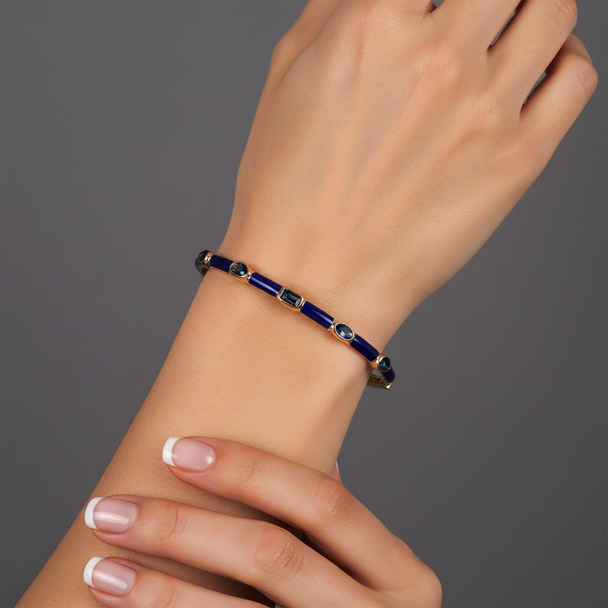 Le bracelet Royal Radiance en or jaune 14K émaillé de topazes bleues est une expression raffinée de l'élégance, mettant en vedette l'or jaune 14K et orné de saphirs bleus captivants et d'accents d'émail bleu. Pesant 8,79 grammes, ce bracelet est