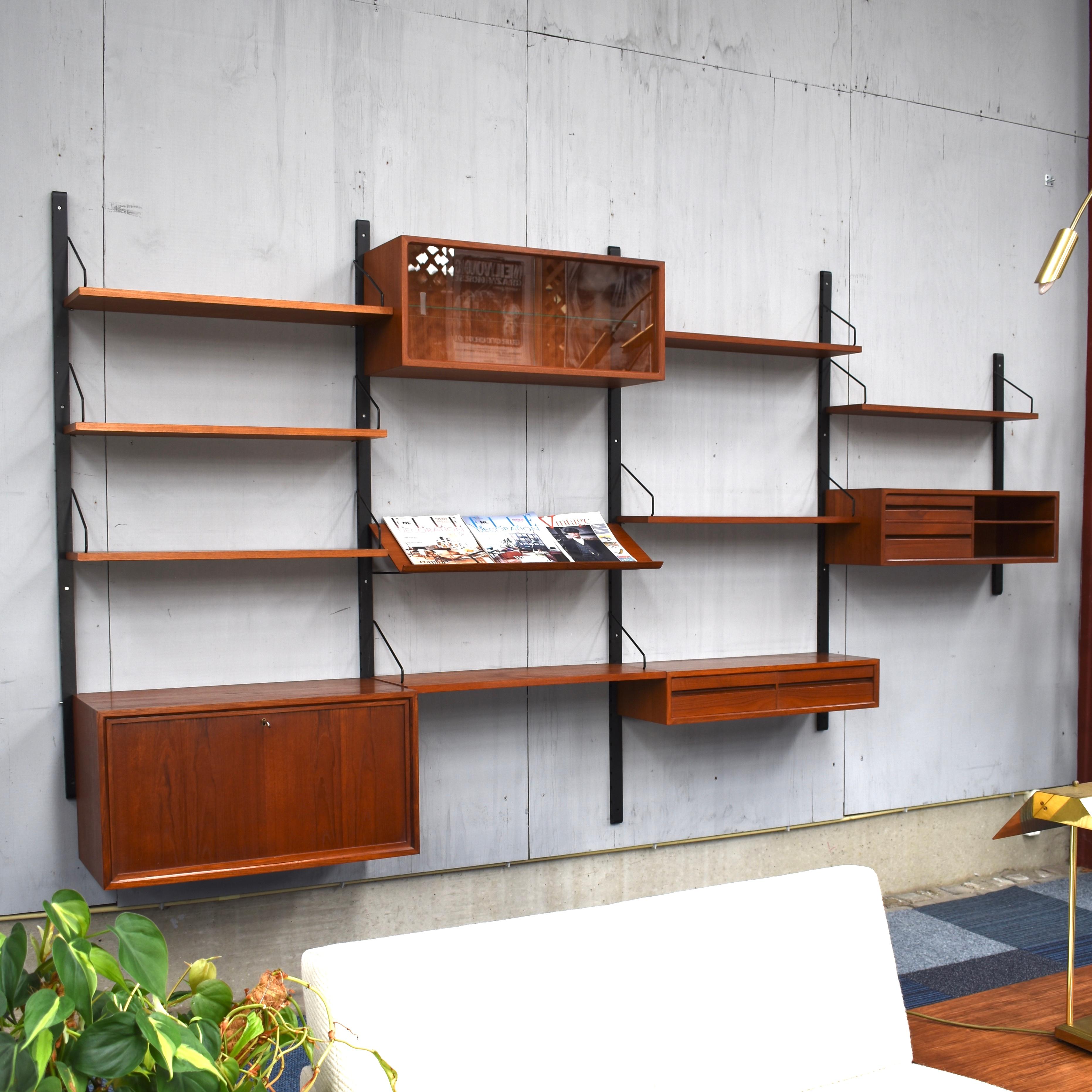 Beautiful Royal series wall unit by Poul Cadovius with much wanted angled lecture shelve. In a beautiful warm wood color and in good condition. The system is modular so it can be arranged to your own liking or expanded with extra units.

This unit