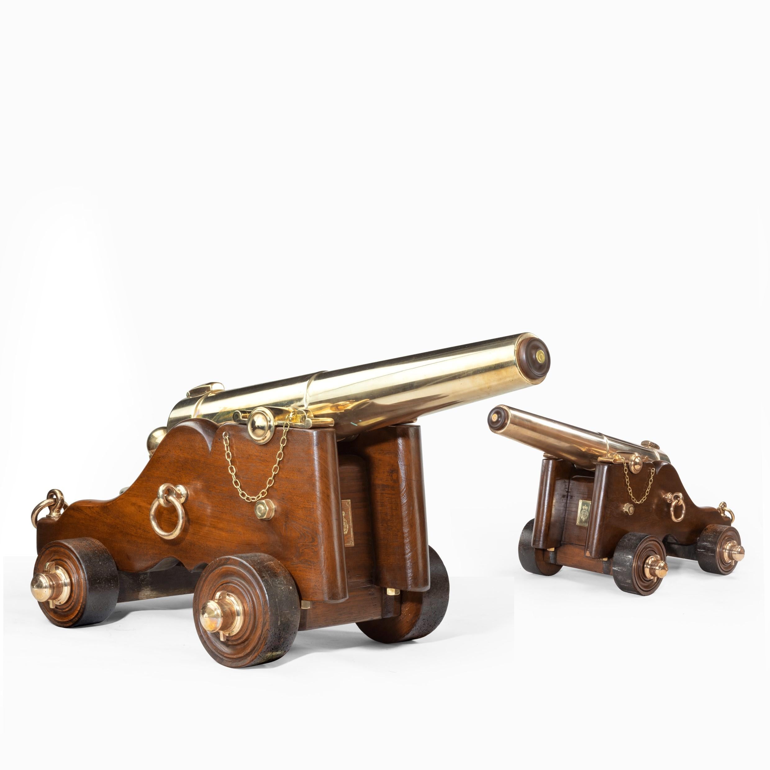 This pair of early Victorian three-stage bronze signal cannon are set on elm carriages with bronze fittings.

Each 39 inch tapering barrel has one reduction and a ball cascabel. The trunnions have chain and pin locks and cast bronze trajectory