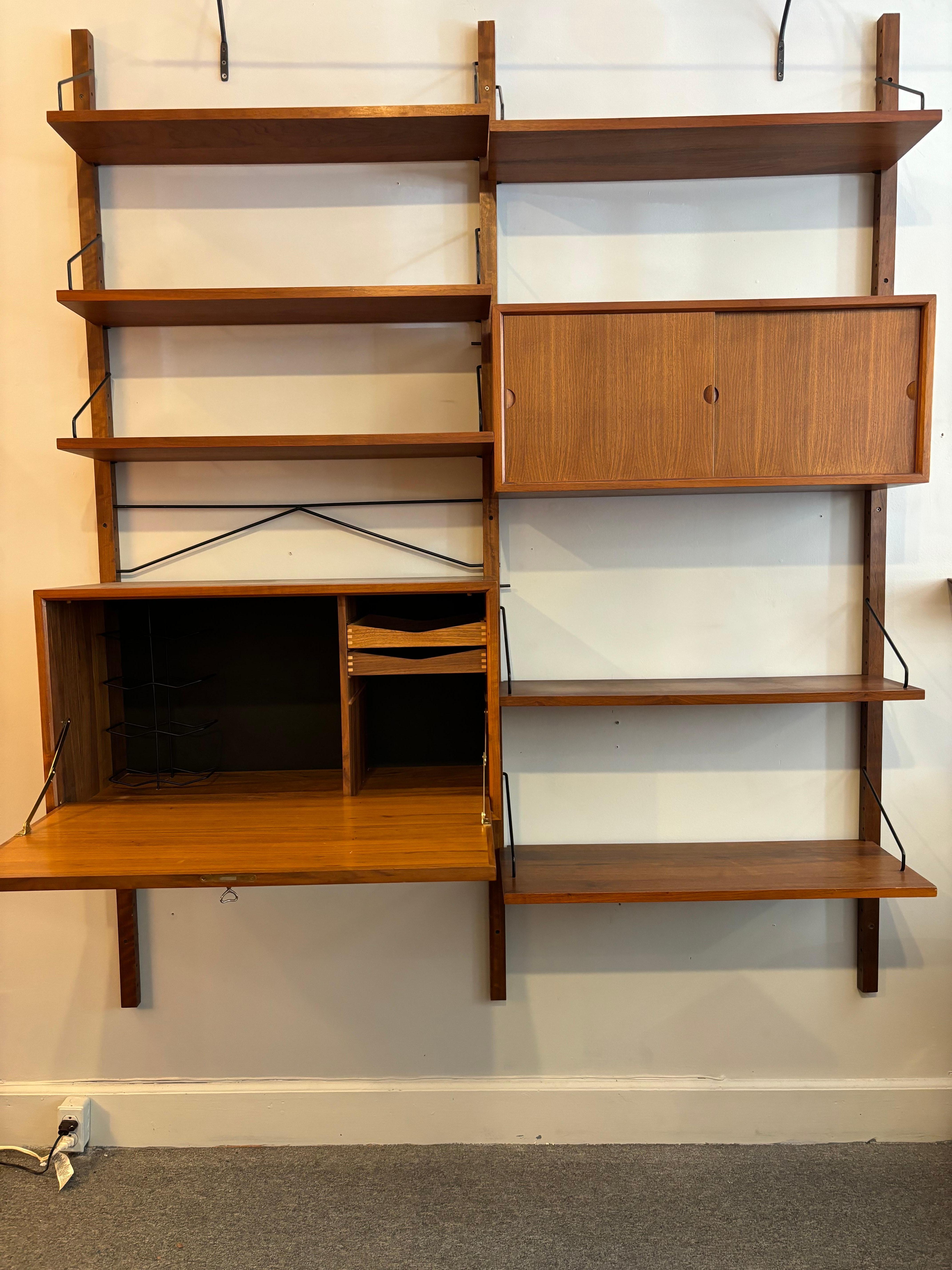 Poul Cadovius Royal Teak Shelf/ Wall System.  Unit is made up of 1 drop down bar cabinet 31.5 wide, 15.5 deep and 16.75 tall.  Unit has a basket weave front door and two dove-tailed sliding drawers and a metl wine holder.  Second sliding door
