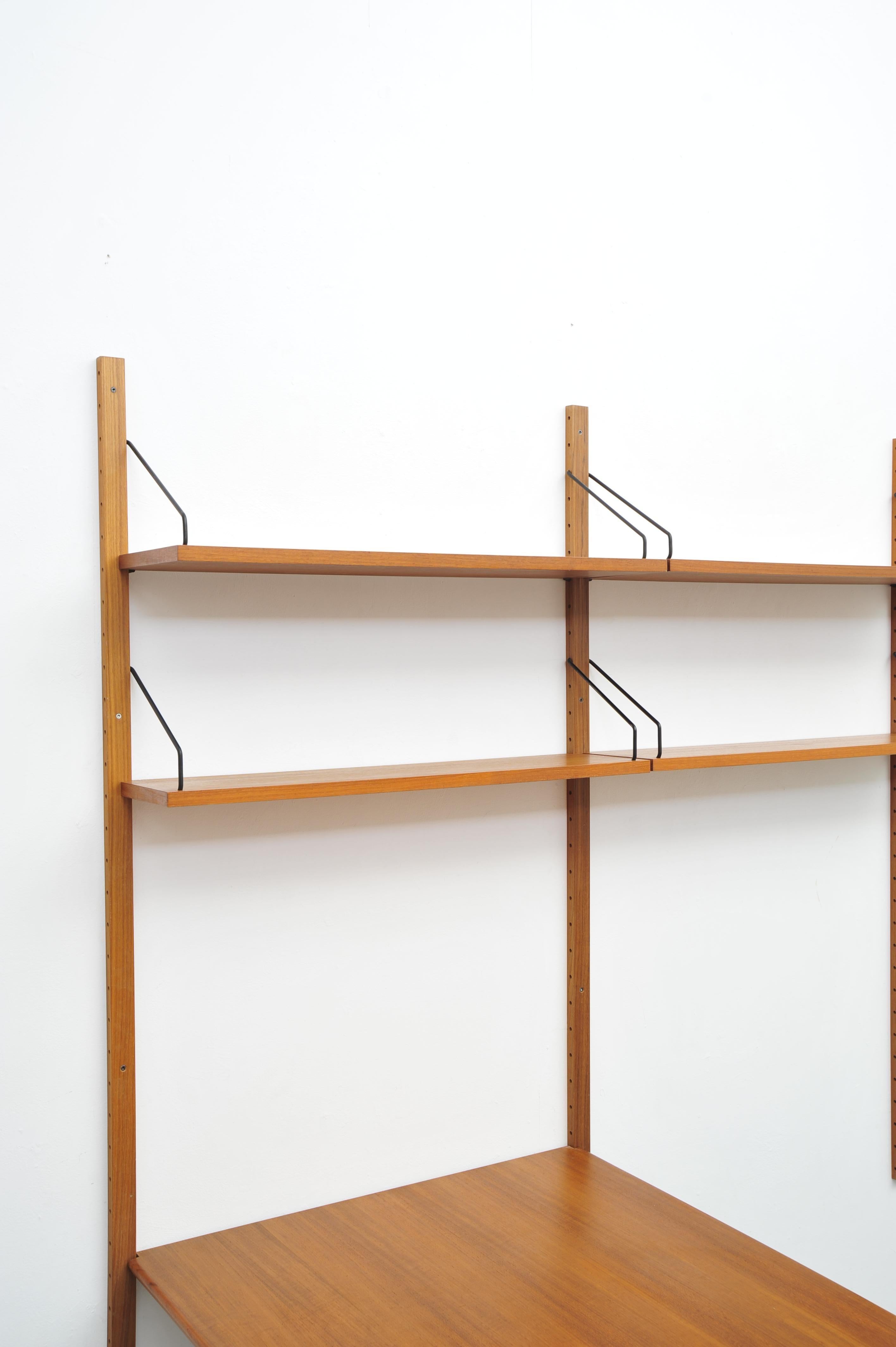 El Royal System de Poul Cadovius, fabricado en los años 50, es un sistema regio de madera de teca muy resistente. Se compone de una mesa de comedor ampliada y cuatro sillas de matrimonio que se adaptan de forma suave e individualizada. Este diseño