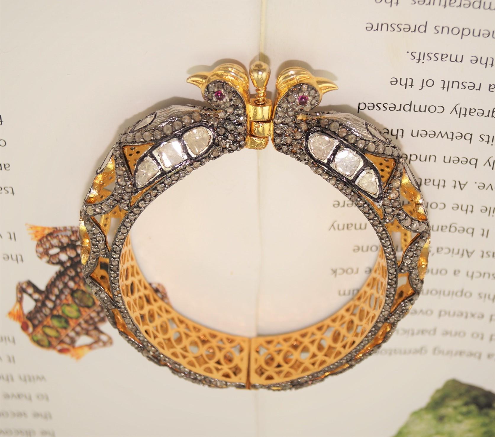 Dieses königliche Pfauenarmband mit Scharnieren besteht aus:

Diamant- 6,30cts
Diamant-Typ: Pave und ungeschliffene Diamanten
Farbe des Diamanten: Weiß und grau gefärbt
Diamant-Zertifikat- Zertifizierte Natürlichkeit
Metall: Silber
Reinheit des