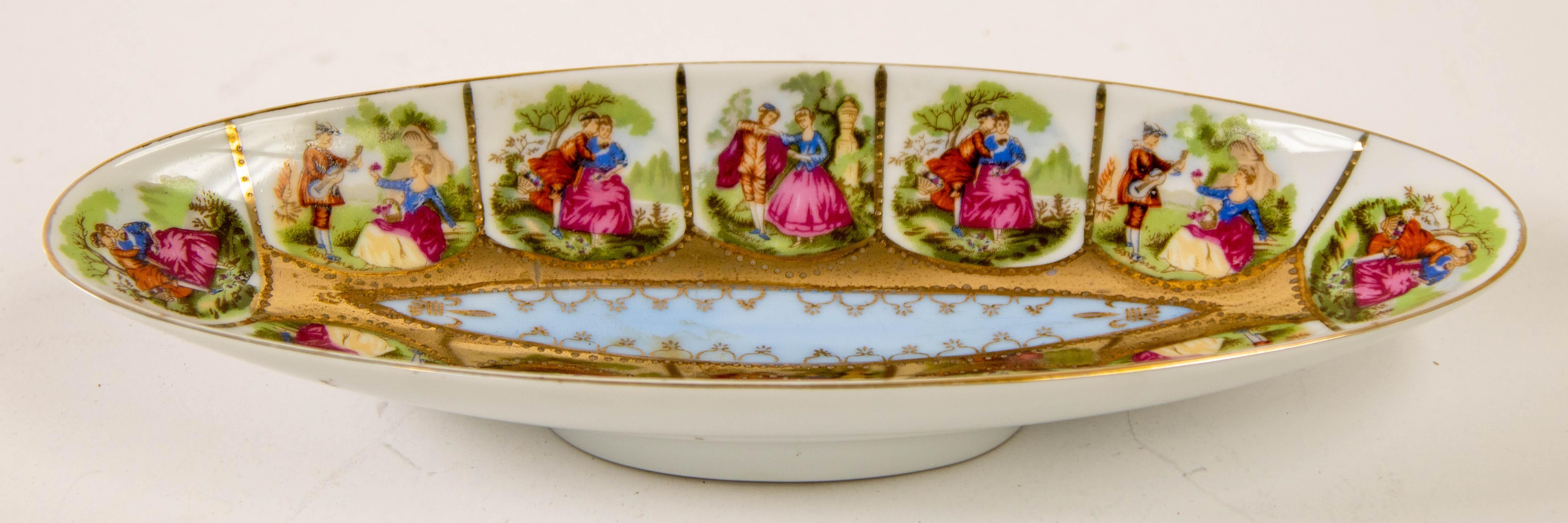 Wir präsentieren ein exquisites Royal Vienna Austria handbemaltes ovales Porzellantablett aus der Zeit um 1940.
Diese Schale hat eine längliche Form, die mit opulenten Goldverzierungen versehen ist.
Der Rand dieses Tabletts ist mit sorgfältiger Hand