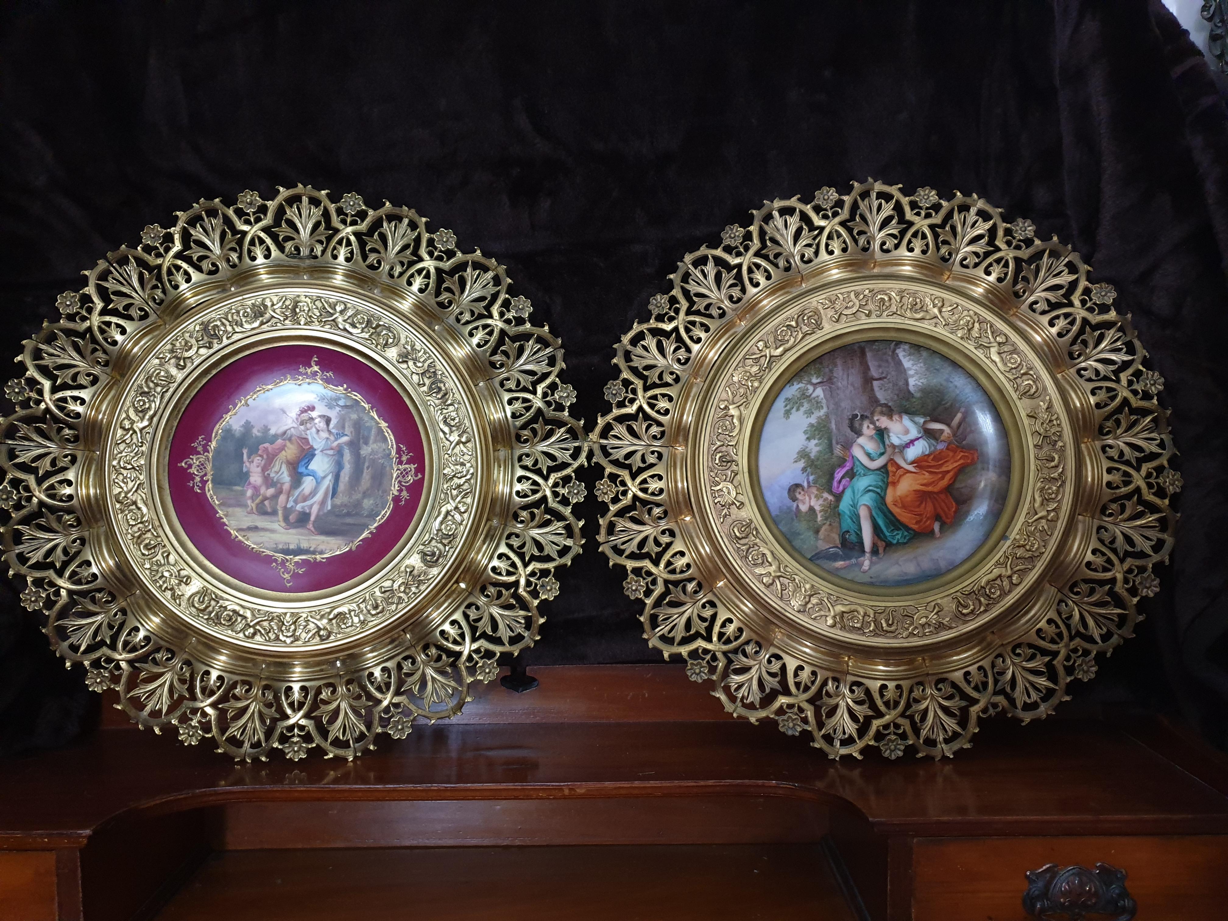 A pair of Royal Vienna hand painted plates framed with a bronze gilt reticulated framework with a frilled edge. Signed by Angelica Kauffman with the Beehive Vienna mark and the lovers names written at the back of plates. Heavy solid gilt bronze with