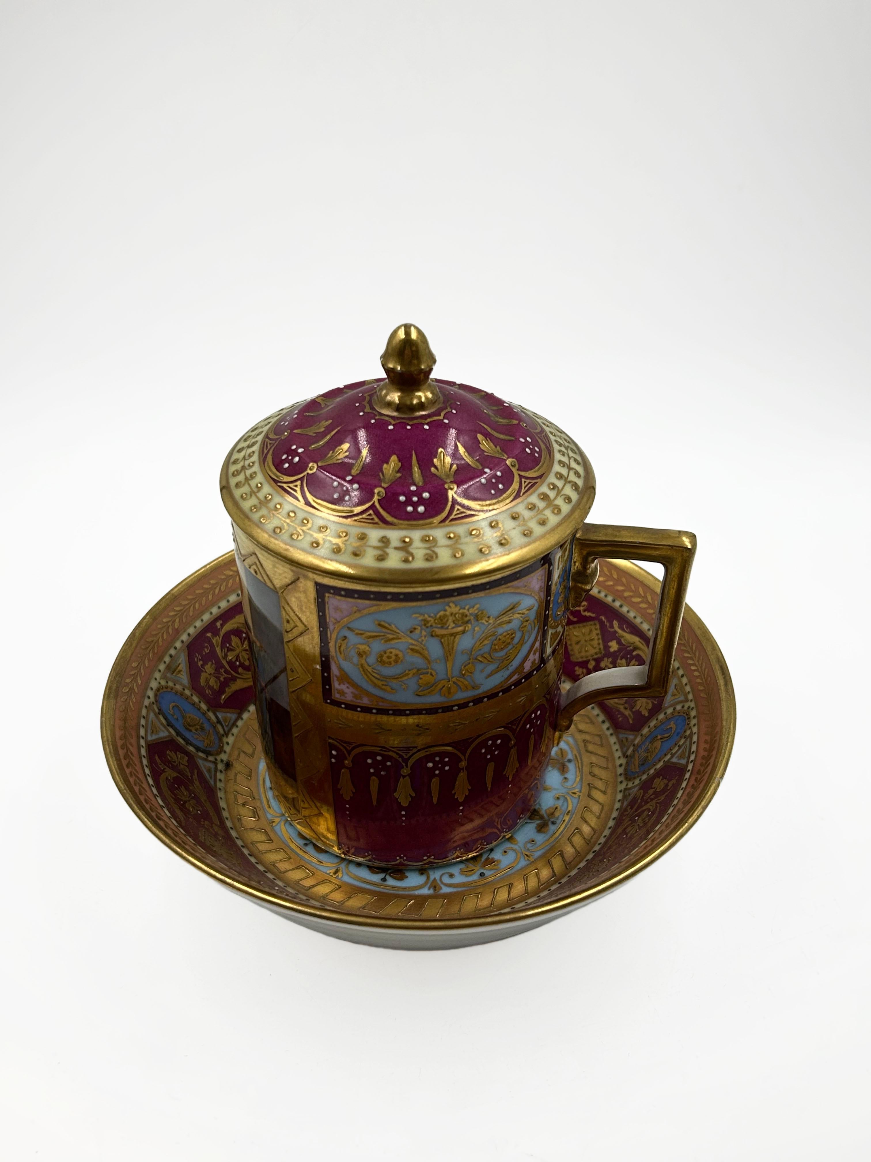 Royal Vienna glasierte Keramiktasse
Glasierte Porzellantasse mit Deckel und Untertasse, Königliches Wien, verziert mit polychromen und goldenen Emaillen. Auf dem Hauptteil sind klassische figürliche Szenen handgemalt, während die geometrischen und