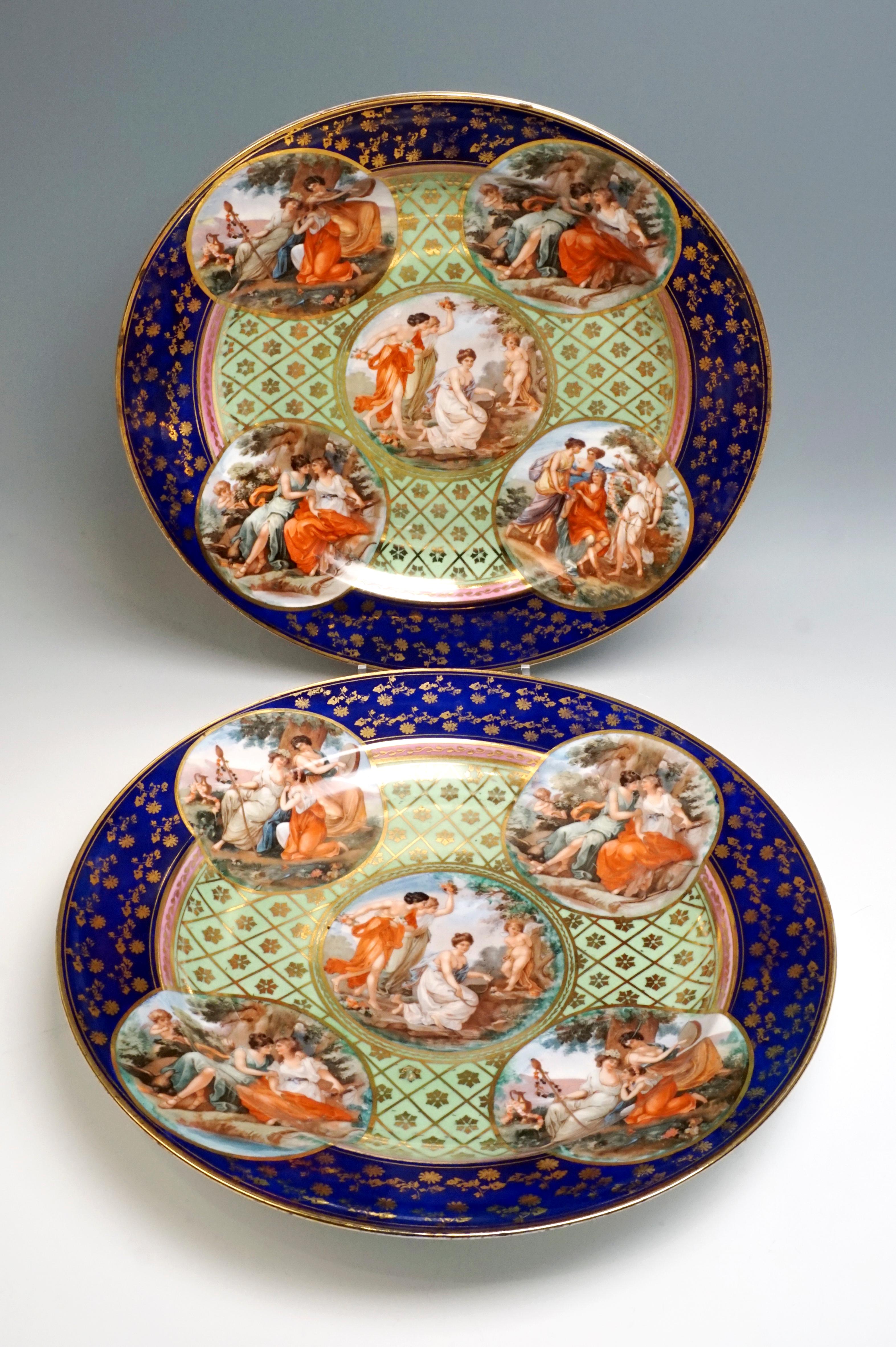 Two large, splendid porcelain plates with elaborate painting: cobalt blue flag with dense, scattered flower painting in gold, delimited by Fine and wider gold rims, collar in pink with a golden bud tendril and subsequent gold rim, mirror with a