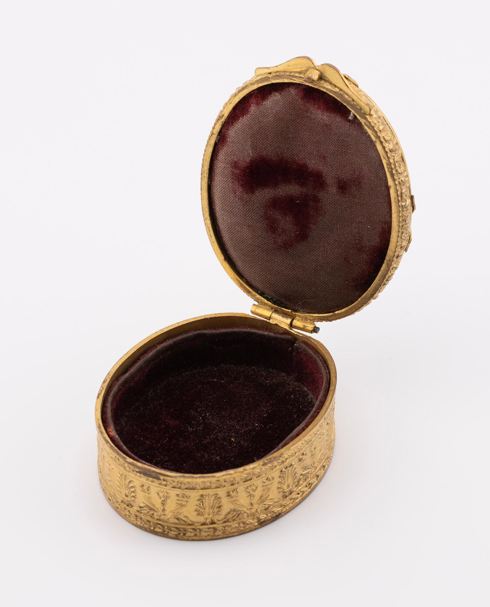 The Vienna Porcelain Manufactory is illustrious for its production of porcelain boxes like this one hand-painted by Franz Wagner. The artist paints a beautiful and luminescent miniature portrait of a beautiful young woman on the oval porcelain. The