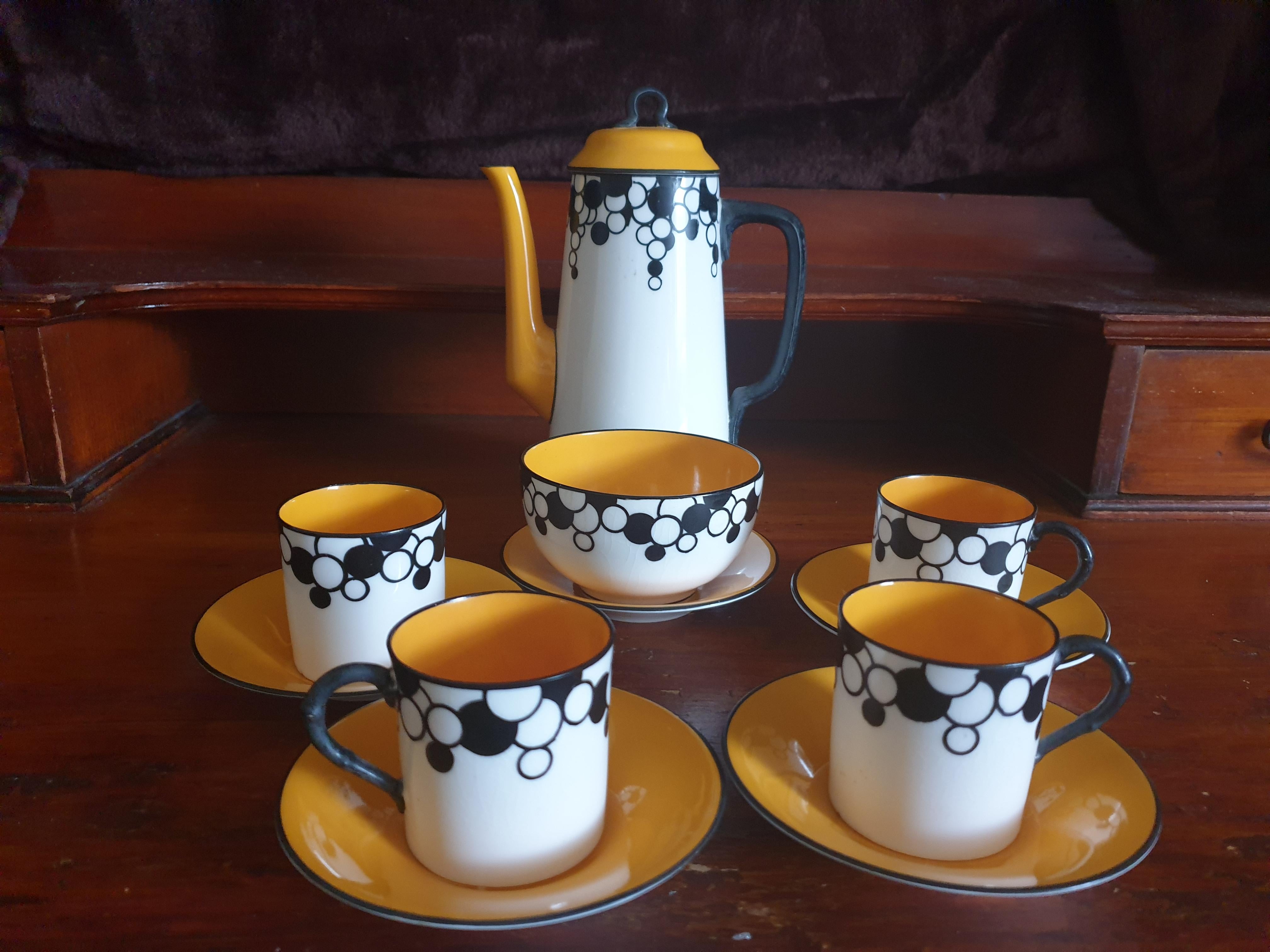 A 1920’s Royal Worcester Art Deco pattern coffee service comprising of a coffee pot, creamer jug,m sugar bowl, five cups and saucers. All decorated with black circles on with background and yellow insides. Makers stamp to the underside dated 1926.