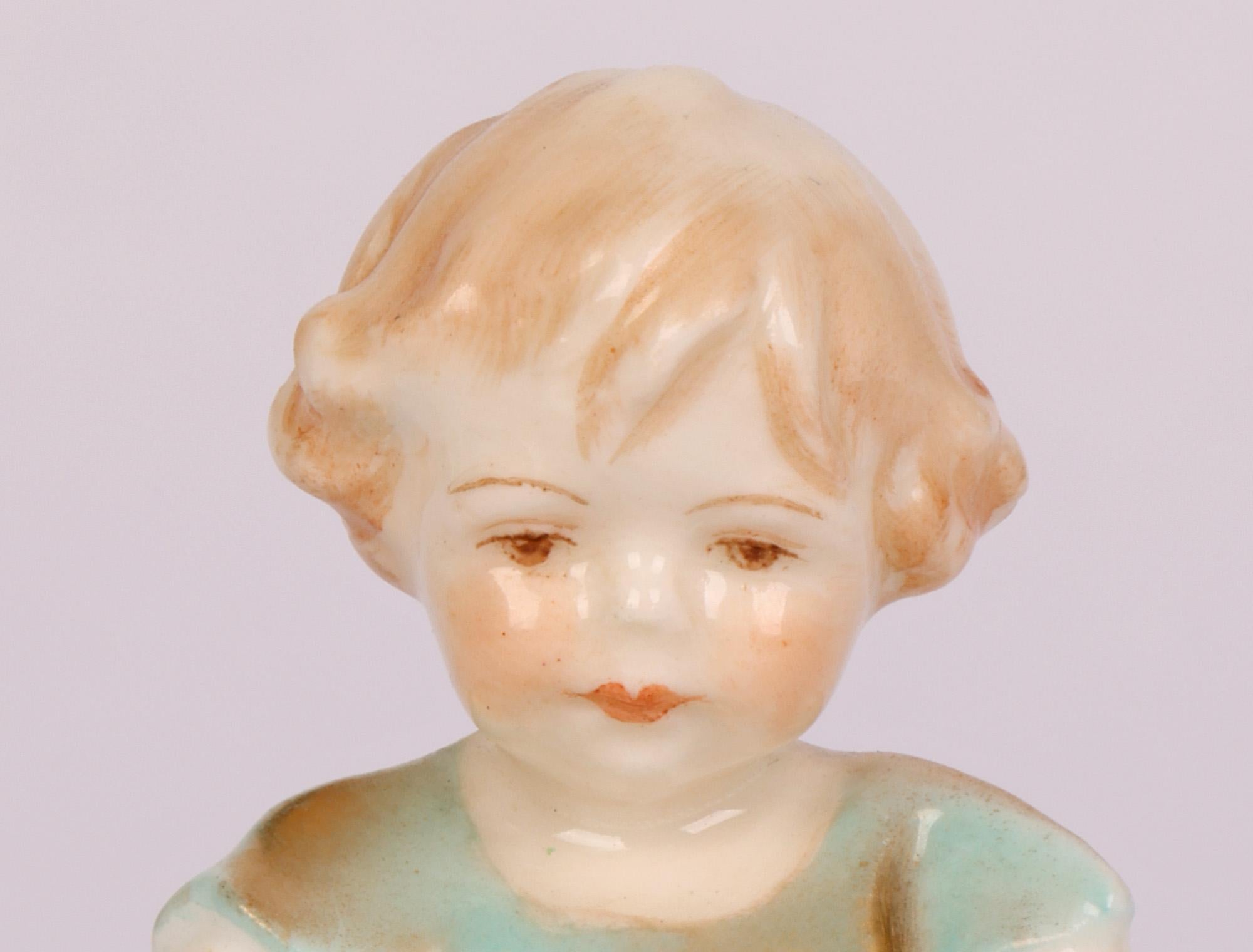 Ravissante et rare figurine en porcelaine Royal Worcester intitulée Joan, modelée par Freda G Doughty et datée de 1935. La très jeune figurine d'enfant repose sur une base en forme de demi-lune et porte une petite robe courte. La figure est bien