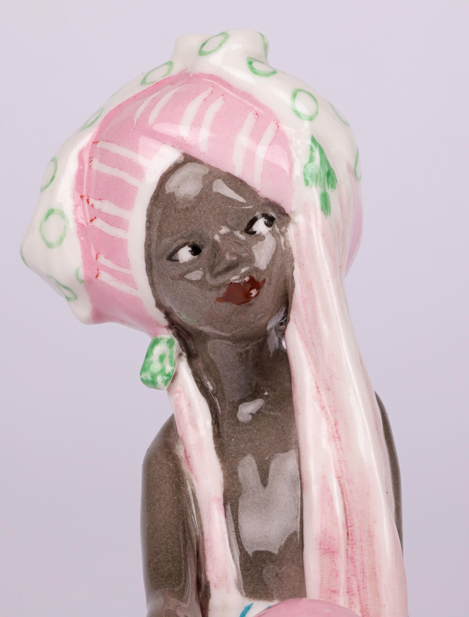 Ravissante figurine en porcelaine anglaise Art Déco intitulée Le Voleur en robe du Moyen-Orient, fabriquée par Royal Worcester et datée de 1936. La figure d'une jeune fille, assise sur un socle rectangulaire, porte une coiffe en forme de turban et