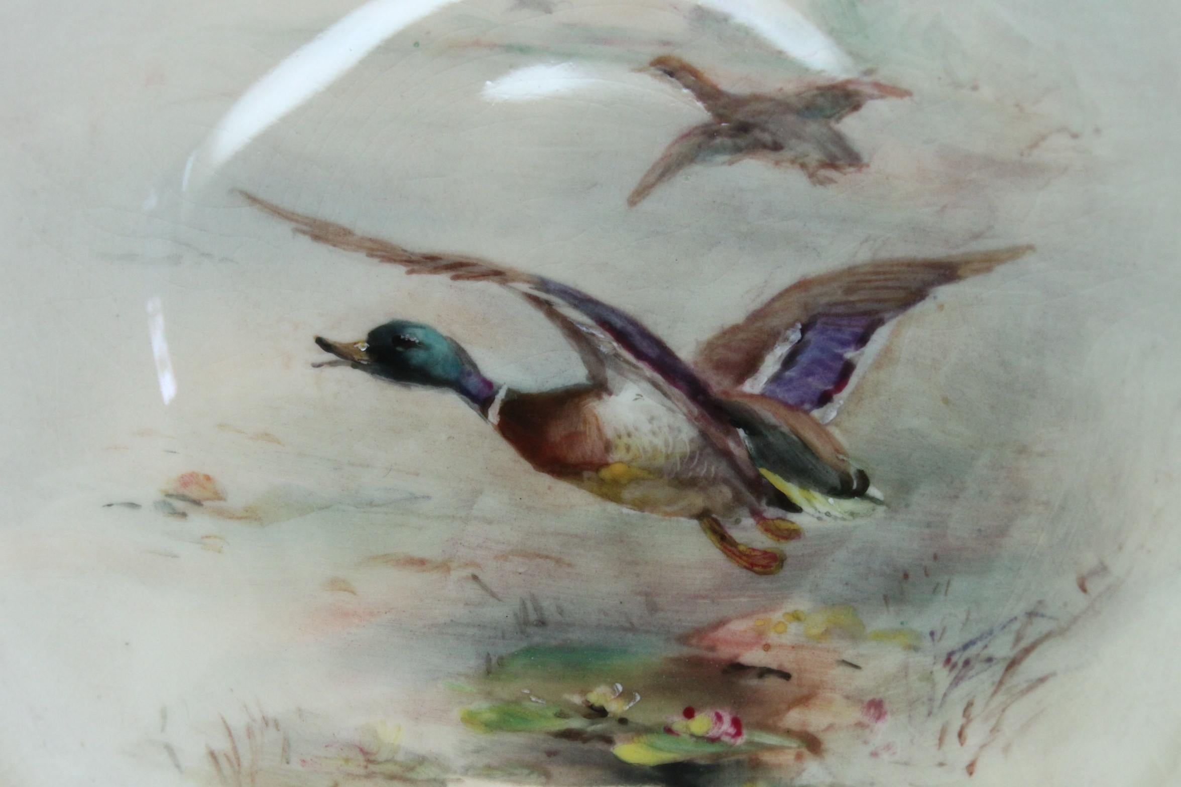 This Royal Worcester footed dish was painted by James Stinton (1870-1961) and features a pair of ducks in flight. The son of John Stinton senior, James Stinton was a member of the famed Stinton family of porcelain painters whose history dated back
