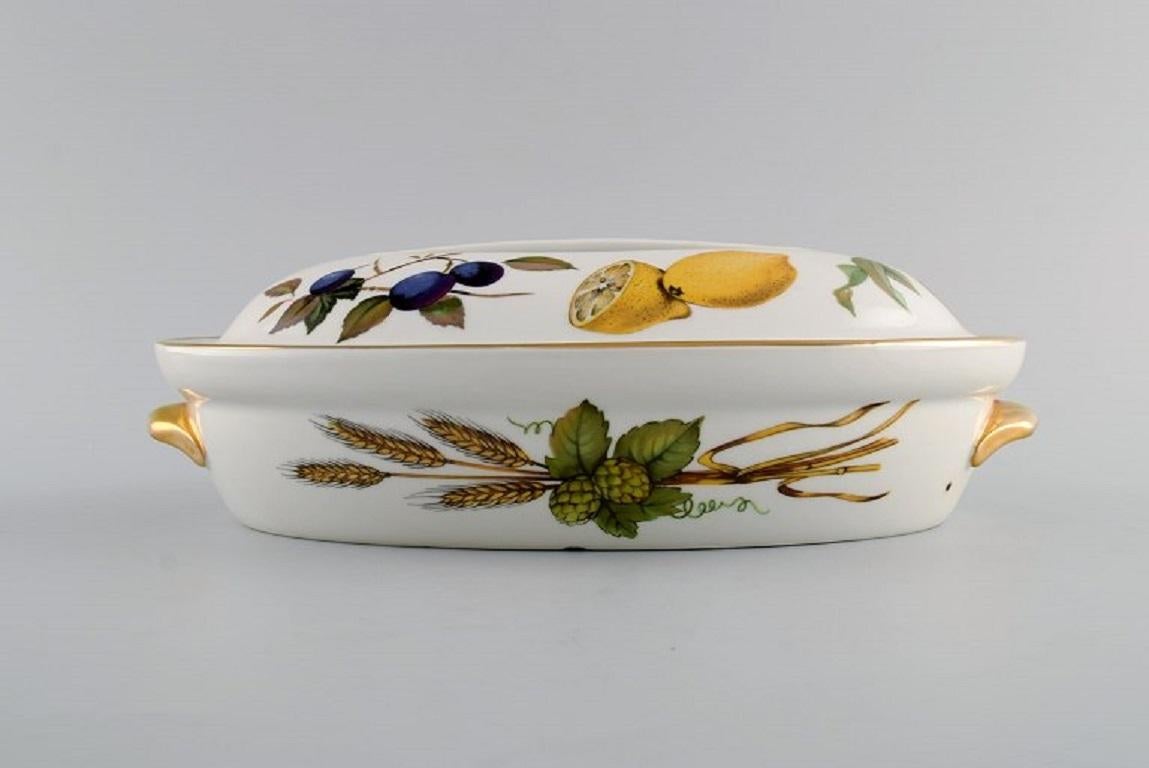 Royal Worcester, England. 
Evesham lidded dish in porcelain decorated with fruits and gold rim. 1960/70s.
Measures: 27 x 9 cm.
In excellent condition.
Stamped.