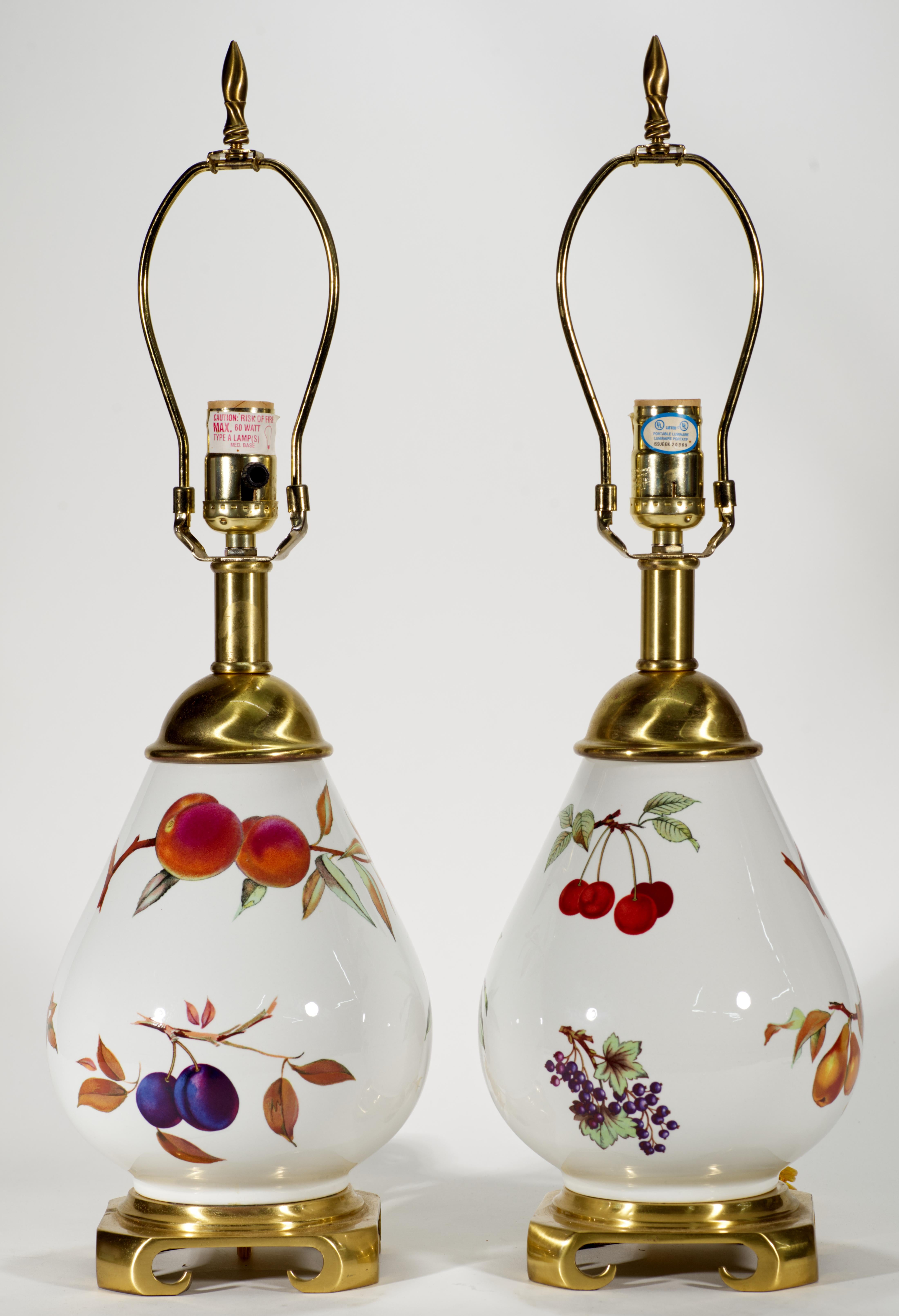  Paire de lampes vintage avec des corps en porcelaine en forme d'urne, décorés dans le motif Evesham, montés sur des bases en laiton de style Chinoiserie, et sertis de couvercles et d'accessoires en laiton. Des natures mortes de fruits et de baies