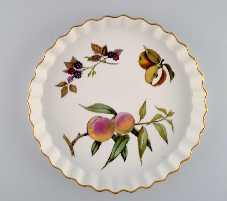 Royal Worcester, England. 
Two Evesham pie dishes in porcelain decorated with fruits and gold rim. 1980s.
Largest measures: 26 x 3.8 cm.
In excellent condition.
Stamped.