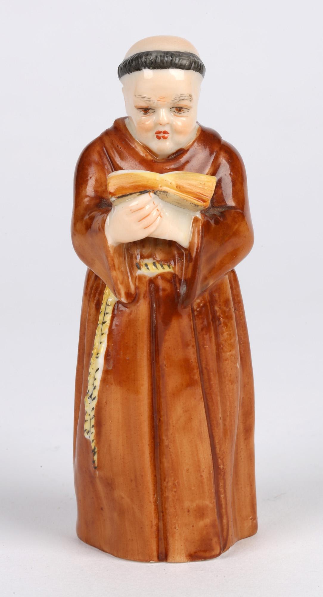 Un éteignoir en porcelaine Royal Worcester très finement réalisé, représentant un moine lisant une bible et daté de 1905. L'éteignoir est représenté comme un moine vêtu d'une robe monastique nouée autour de la taille, tenant une bible ouverte dans
