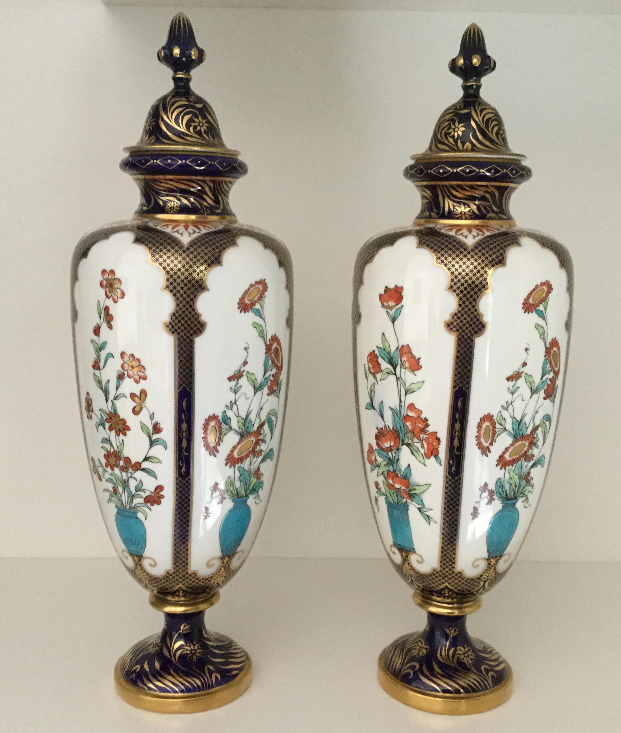 A rare pair of decorative 19th century Royal Worcester porcelain vases decorated in the Japonesque taste, dated 1896-1897.

Each vase is decorated with five white panels containing colorful red floral displays in turquoise urns, the panels are