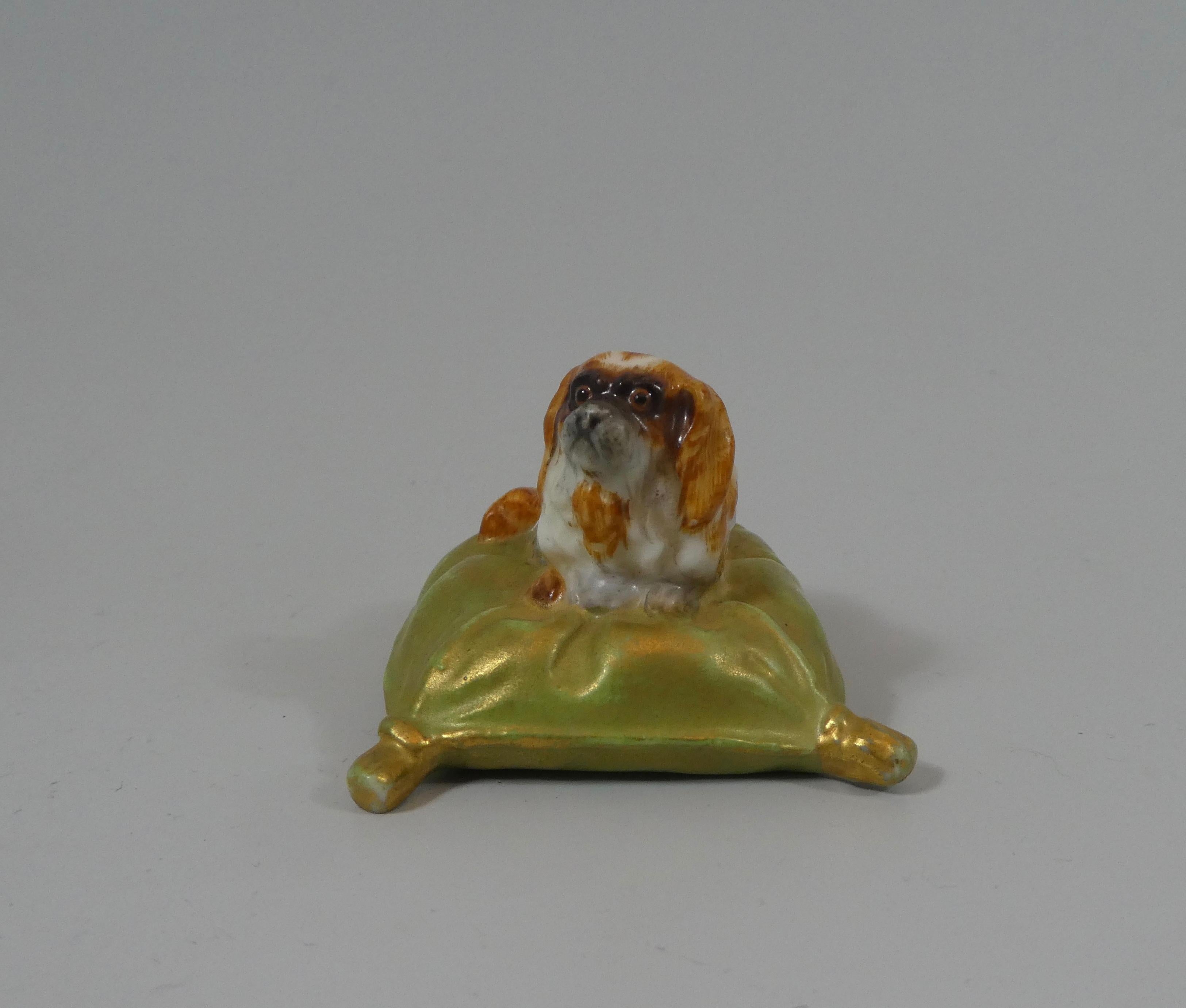 Royal Worcester porcelain figure, dated 1901. Finely and charmingly modelled as a King Charles spaniel, lying upon a large, gilt tasseled cushion. The Spaniel painted with tan colored spots.
Green printed factory marks, and date code for