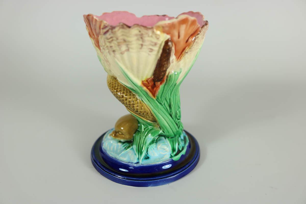 Royal Worcester Majolica posy holder which features a dolphin supporting a shell on it's tail. Colouration: green, cream, red, are predominant. The piece bears maker's marks for the Royal Worcester pottery.