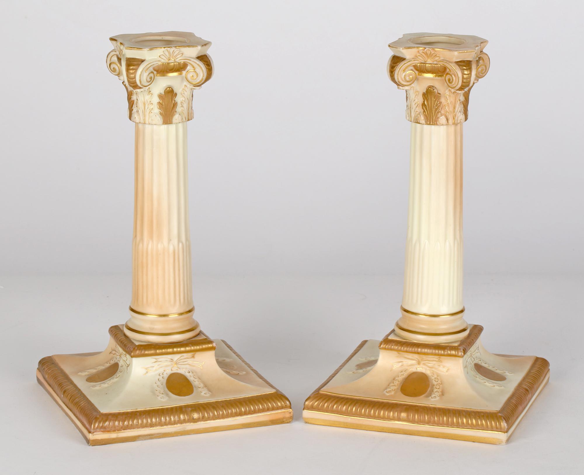 A very fine pair antique Royal Worcester classical porcelain column candlesticks decorated in blush ivory glazes dated 1892. The candlesticks stand raised on a square pedestal base with molded rounded tall columns with ornate leaf and scroll square