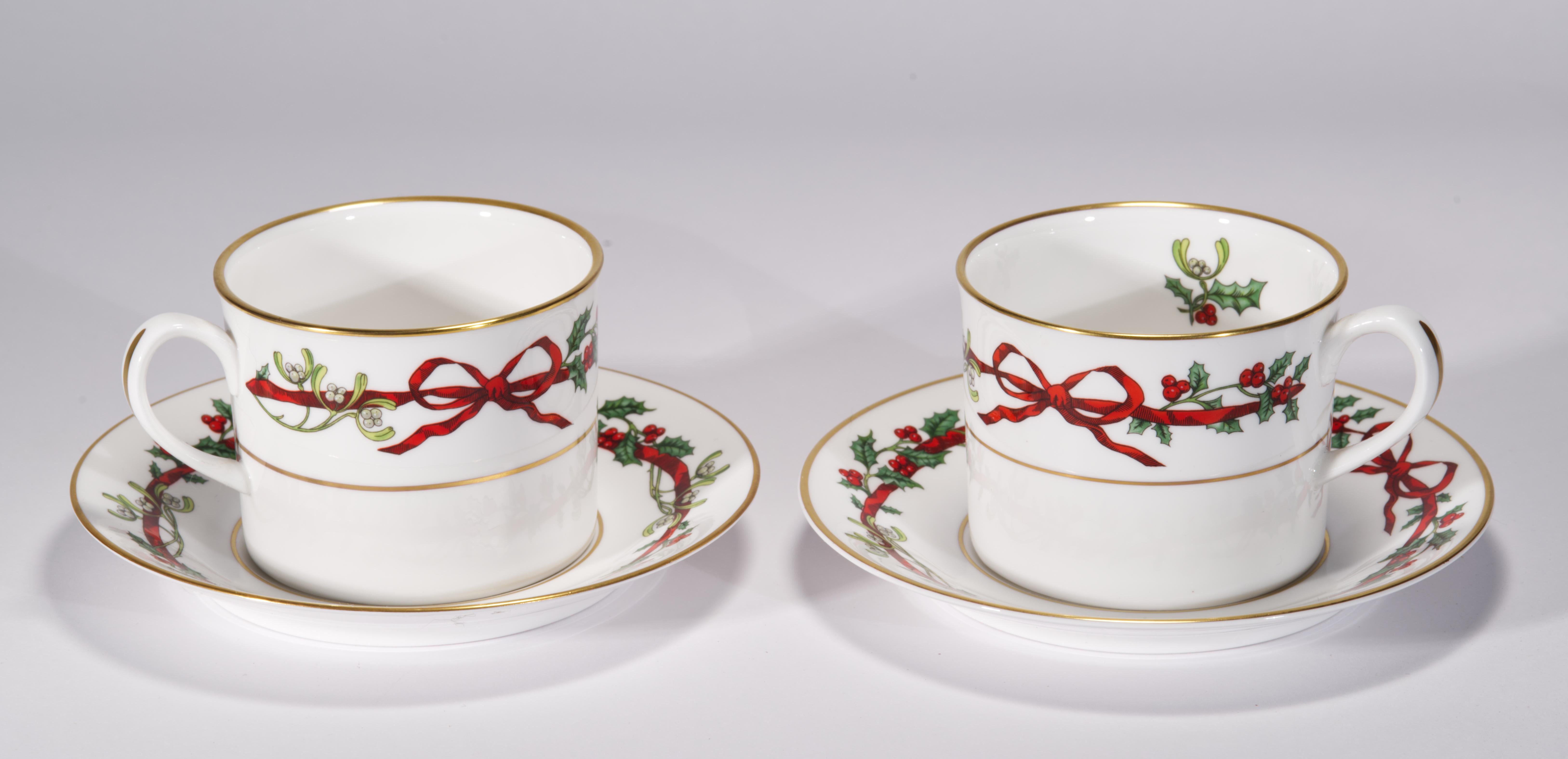  Pair of flat cup and saucer sets was made in England of fine bone china by Royal Worcester and decorated in Holly Ribbons pattern. Holly Ribbons is an exquisite dinnerware pattern that represents the essence of the holiday season, with bright red
