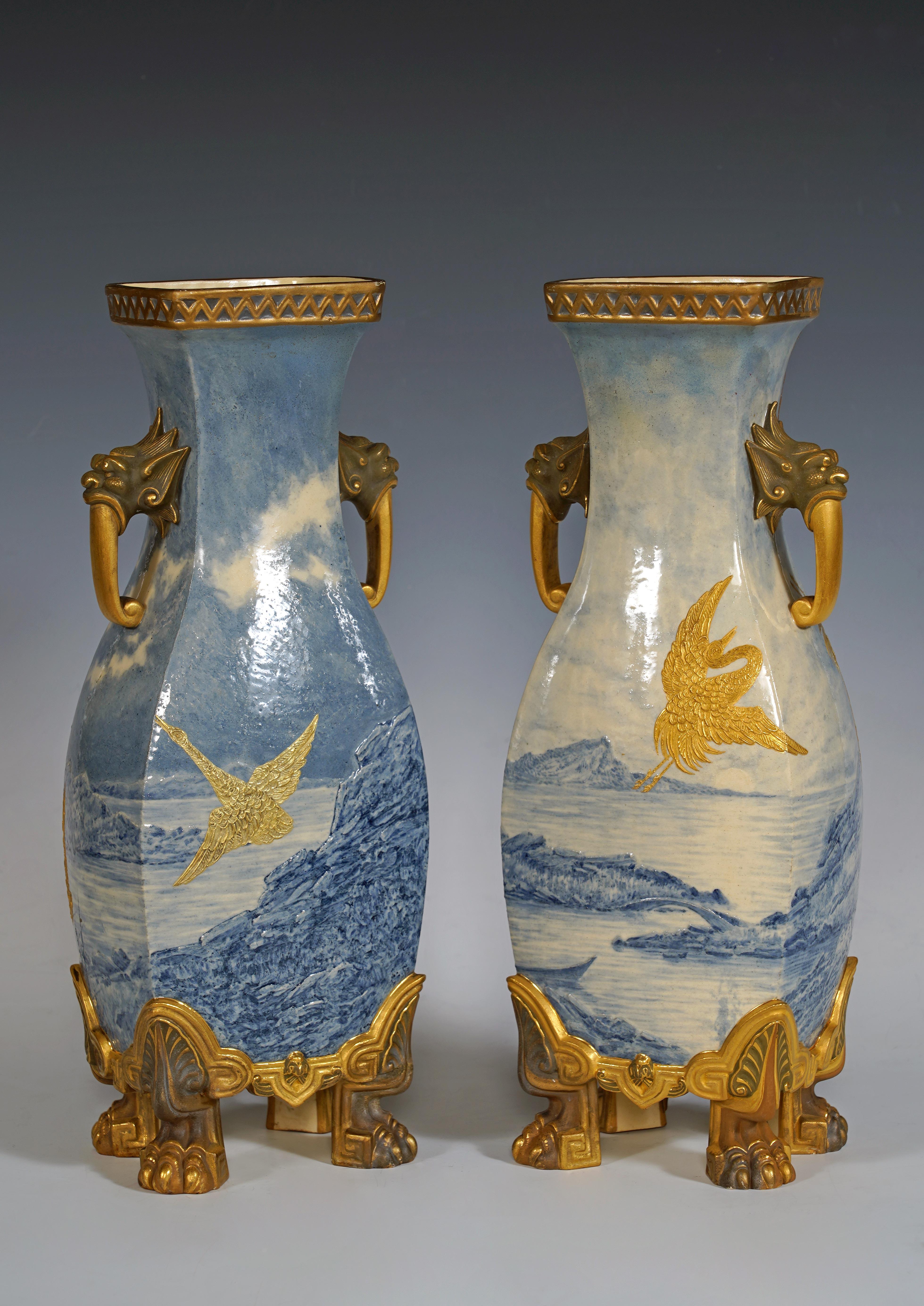 Pareja de jarrones japoneses con forma de balaustre y lados cortados, de porcelana Royal Worcester. Están decoradas con un decorado giratorio de paisajes marinos en monocromo azul realzado con oro, sobrevolado por grullas. Flanqueadas por asas en