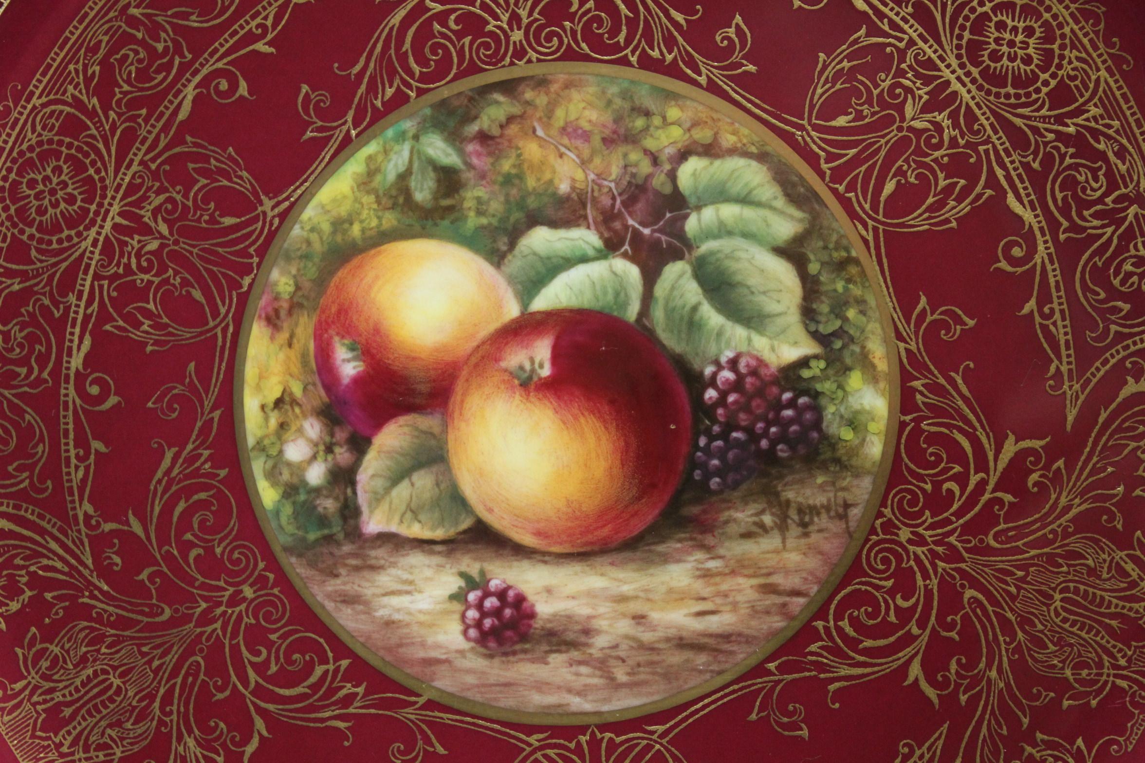 This Royal Worcester porcelain cabinet plate is decorated with a centrepiece of fruit painted by James Skerrett (b. 1954) who joined Royal Worcester in 1969 and specialised in limited editions and paintings of fruit. The centrepiece, which features