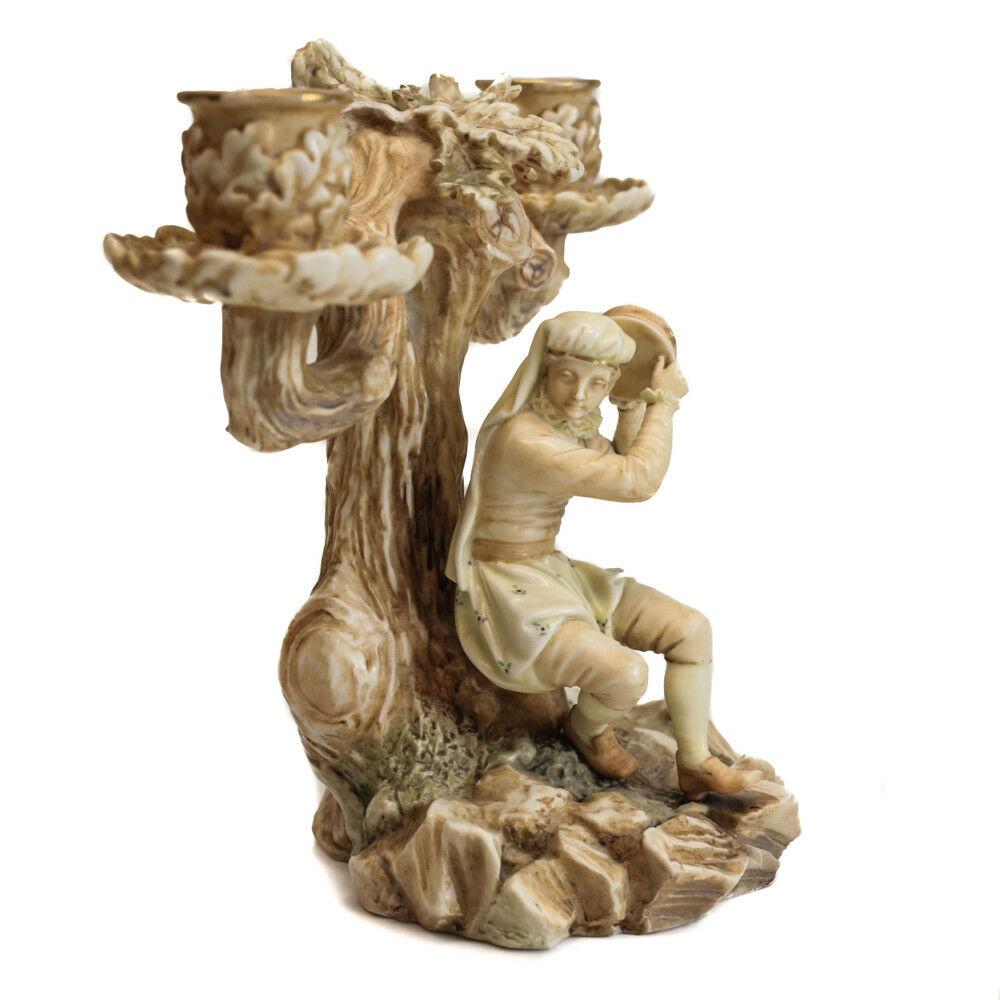 Royal Worcester Porcelain Blush Ivory Candelabra, Figural Tambourine Man, 1885

The stem of the candelabra depicts a tambourine player sitting on a side of a tree. Marked to the underside base.

Additional Information:
Color: Blush Ivory	
Type: