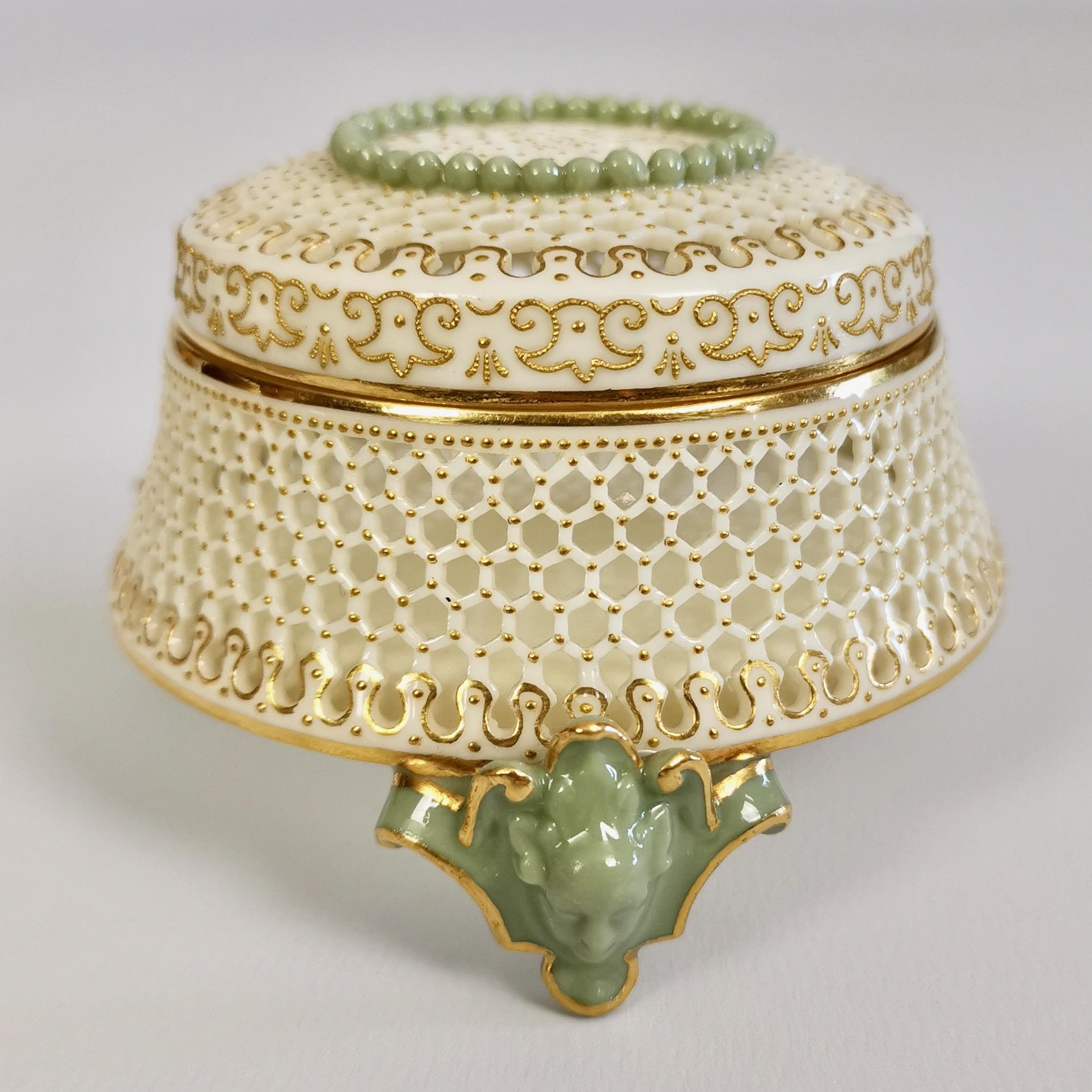 This is an important and sublimely made candy box and cover created by George Owen at Royal Worcester in the year 1909. The box is delicately reticulated (pierced), stands on three masked celadon feet and has very fine raised gilt patterns.

The