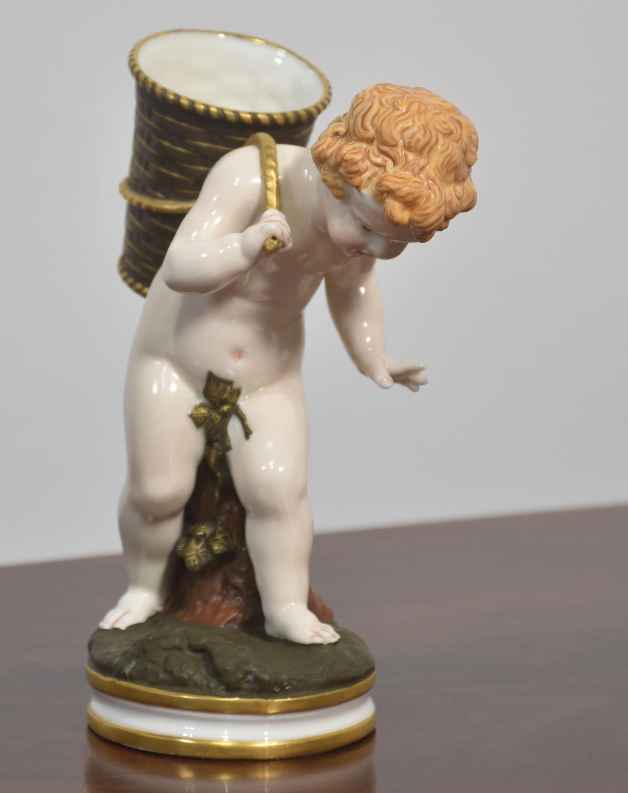 A beautifully crafted Royal Worcester porcelain figurine depicting a cherub carrying a large basket on its back. The figure is rendered with exquisite attention to detail, showcasing the soft modelling and delicate hand-painting characteristic of