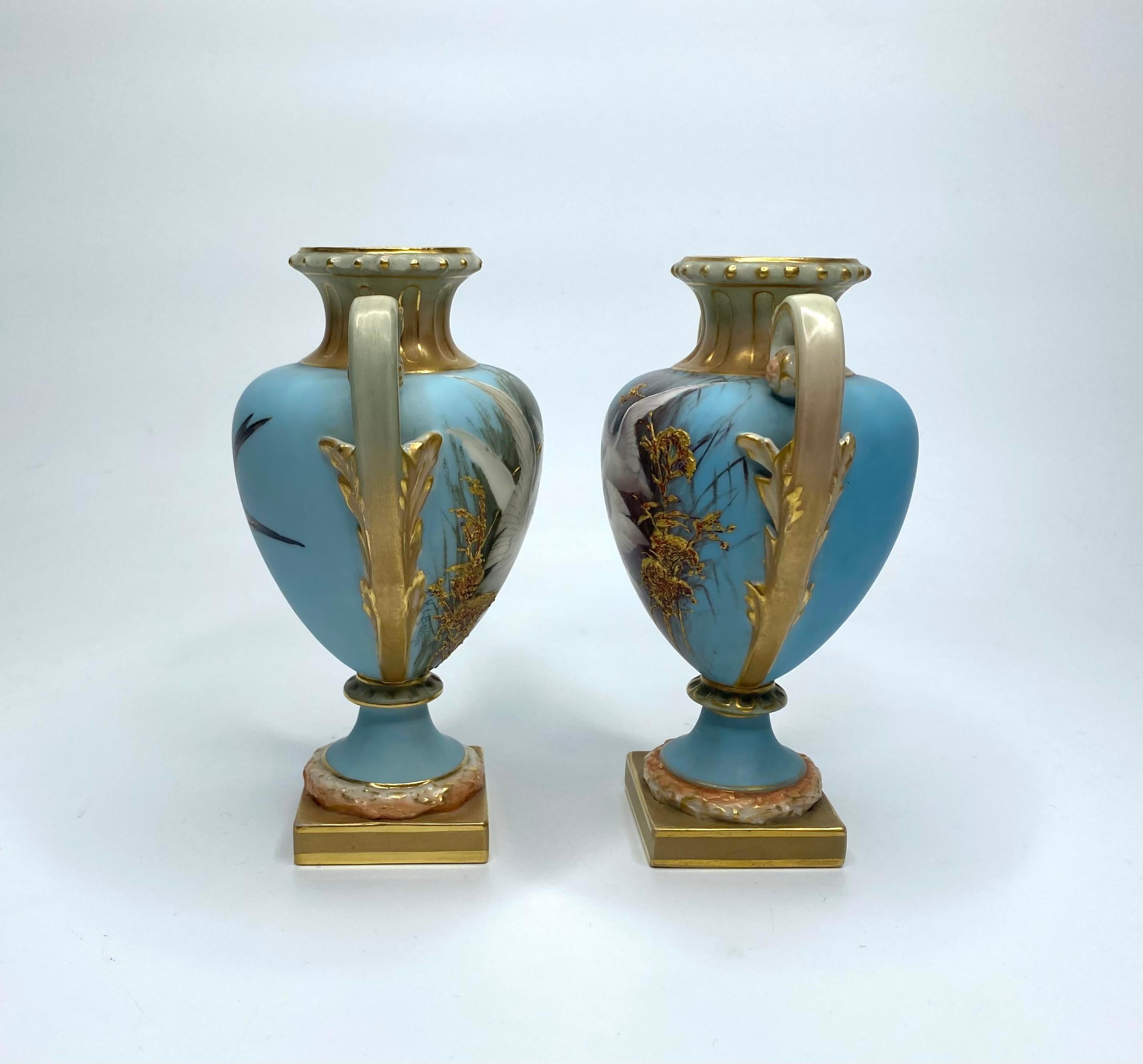 Paire de vases en porcelaine Royal Worcester, peints par Charles Baldwyn, datés de 1904. Peint à la main avec des cygnes émergeant des roseaux, sur un fond turquoise.
Les inverses avec les hirondelles en vol.
Les deux vases sont dotés de deux anses