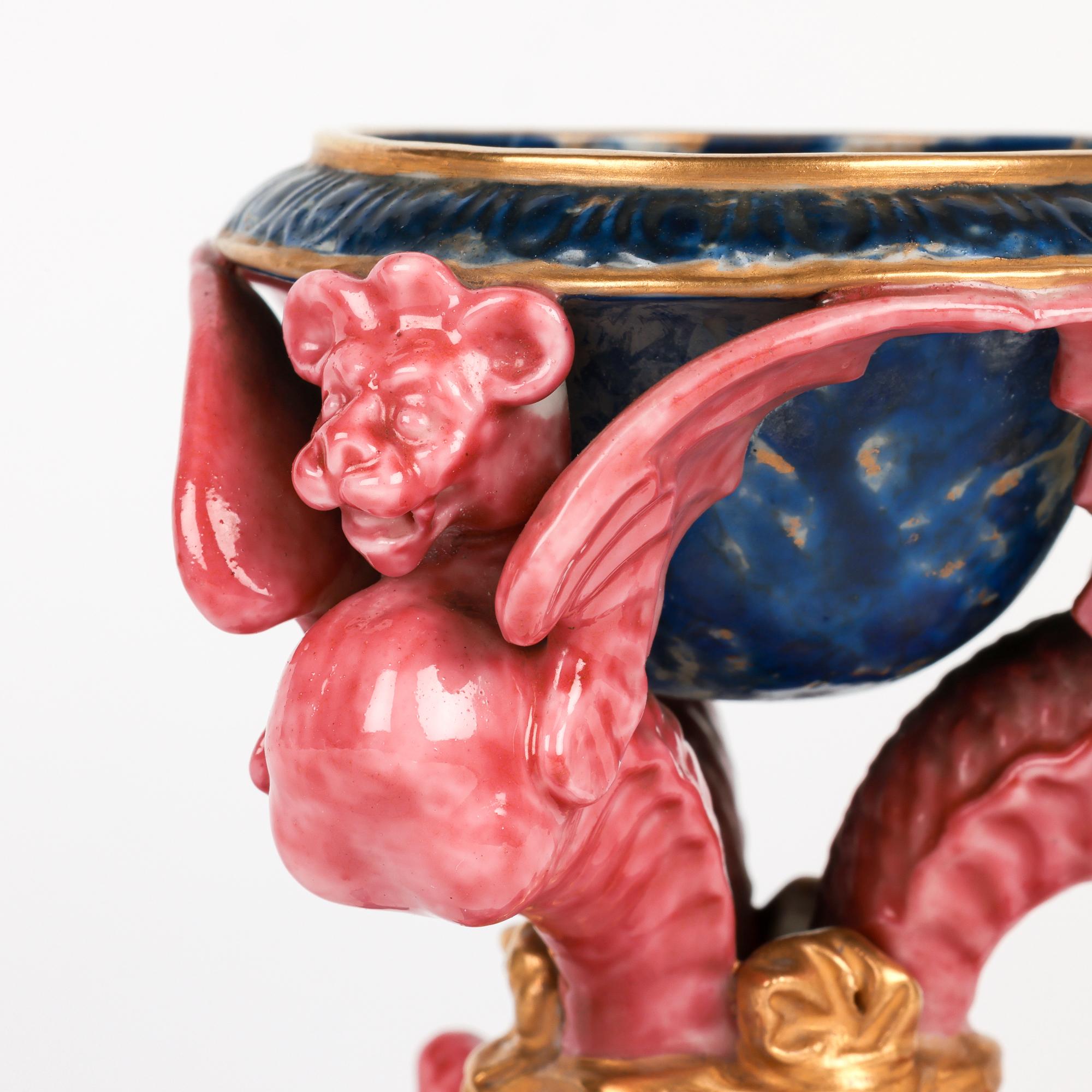 Excepcional y rarísimo juego Royal Worcester de cuatro sales de mesa de porcelana jaspeada sostenidas por grifos alados fechado en 1863. Este asombroso conjunto consta de cuatro pequeñas sales de mesa, cada una sobre una base triforme con pie plano