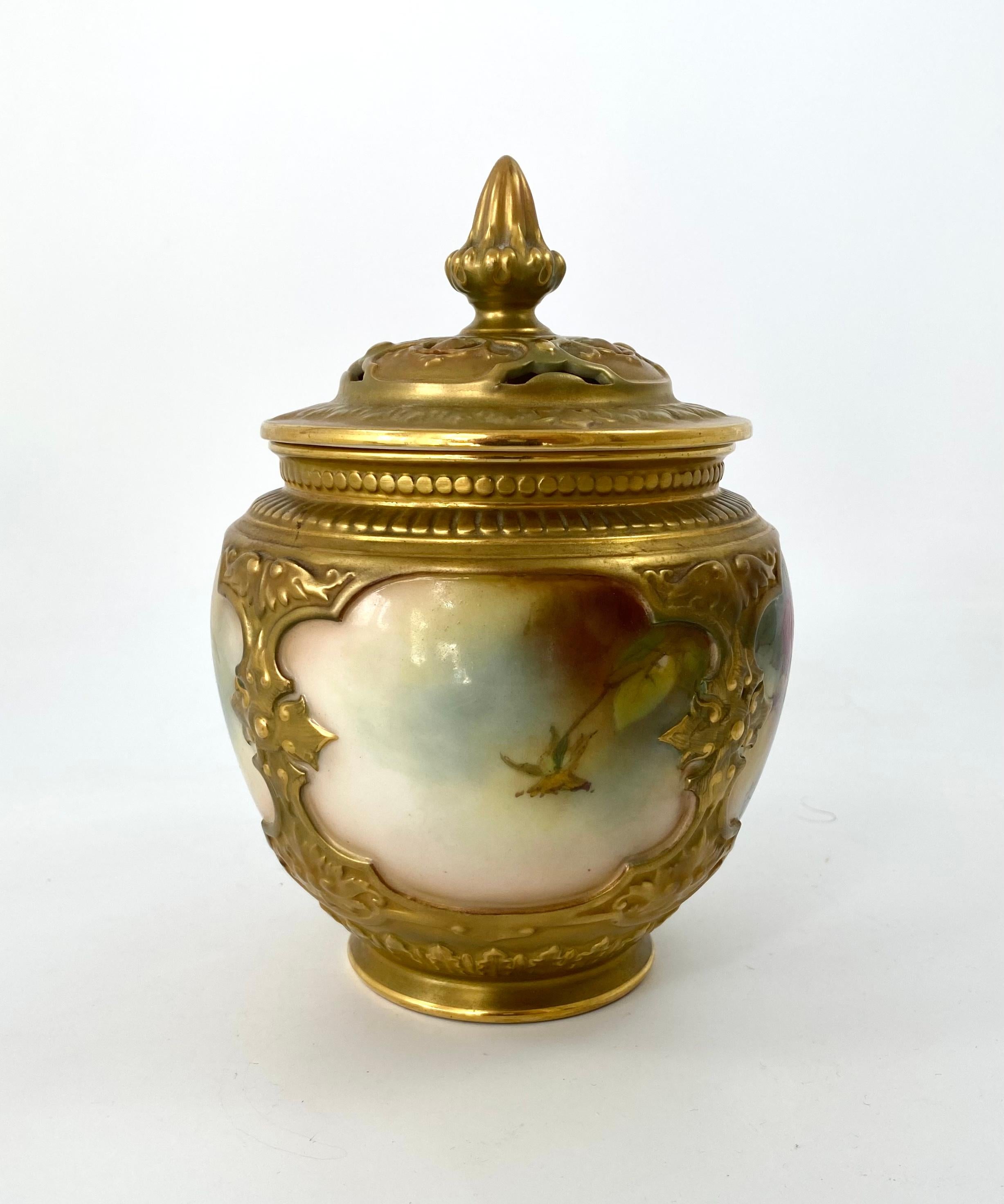 A large Royal Worcester porcelain pot pourri and cover, dated 1913. Hand painted with a spray of roses, within heavily moulded borders, and above a continuous acanthus leaf moulded foot.
The pierced cover, similarly moulded, and having a tall bud