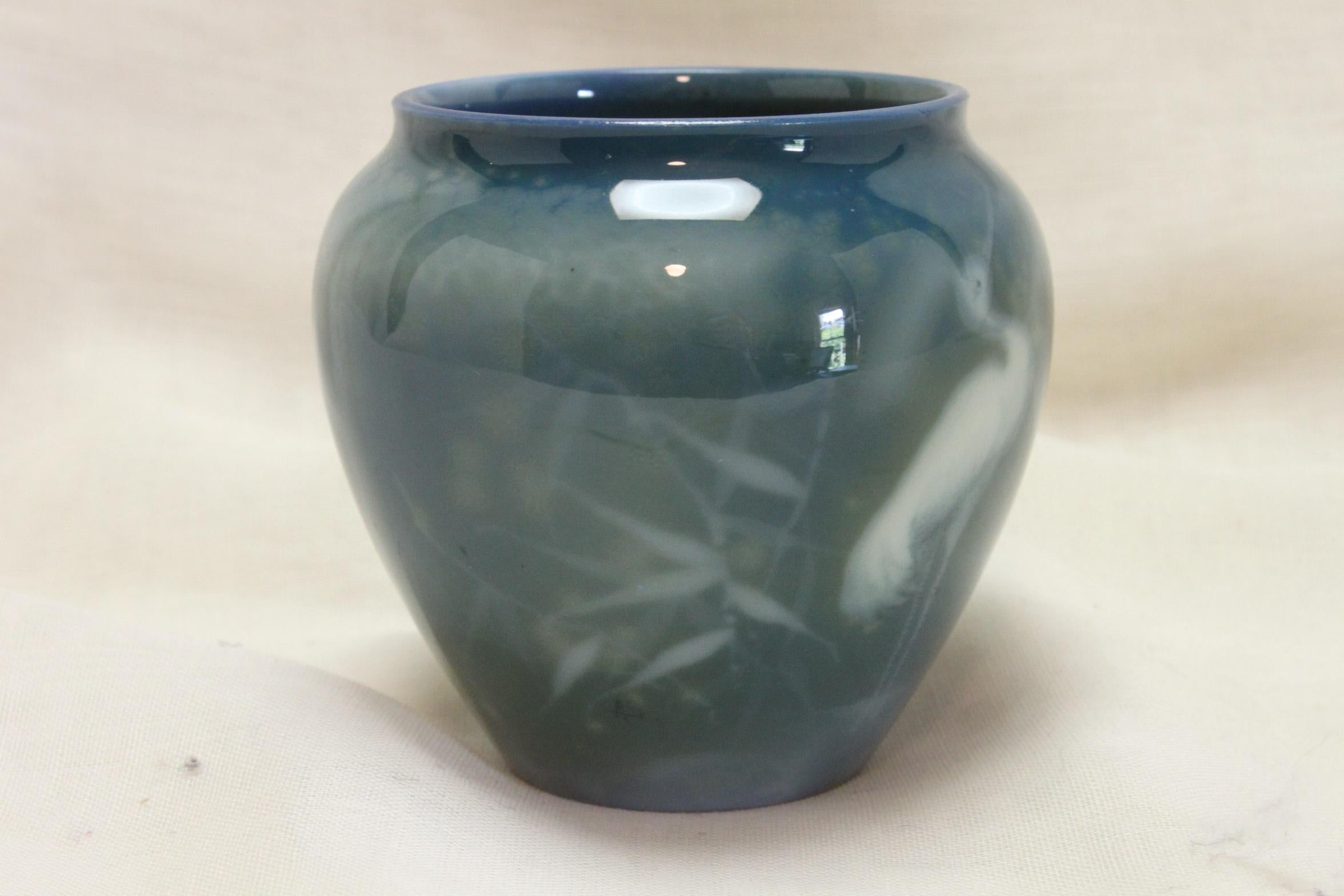 This small urn shaped vase is from Royal Worcester's Sabrina Ware range and is decorated with a mist-like scene of a stork standing near some bamboo. Just below the bamboo, it is signed 