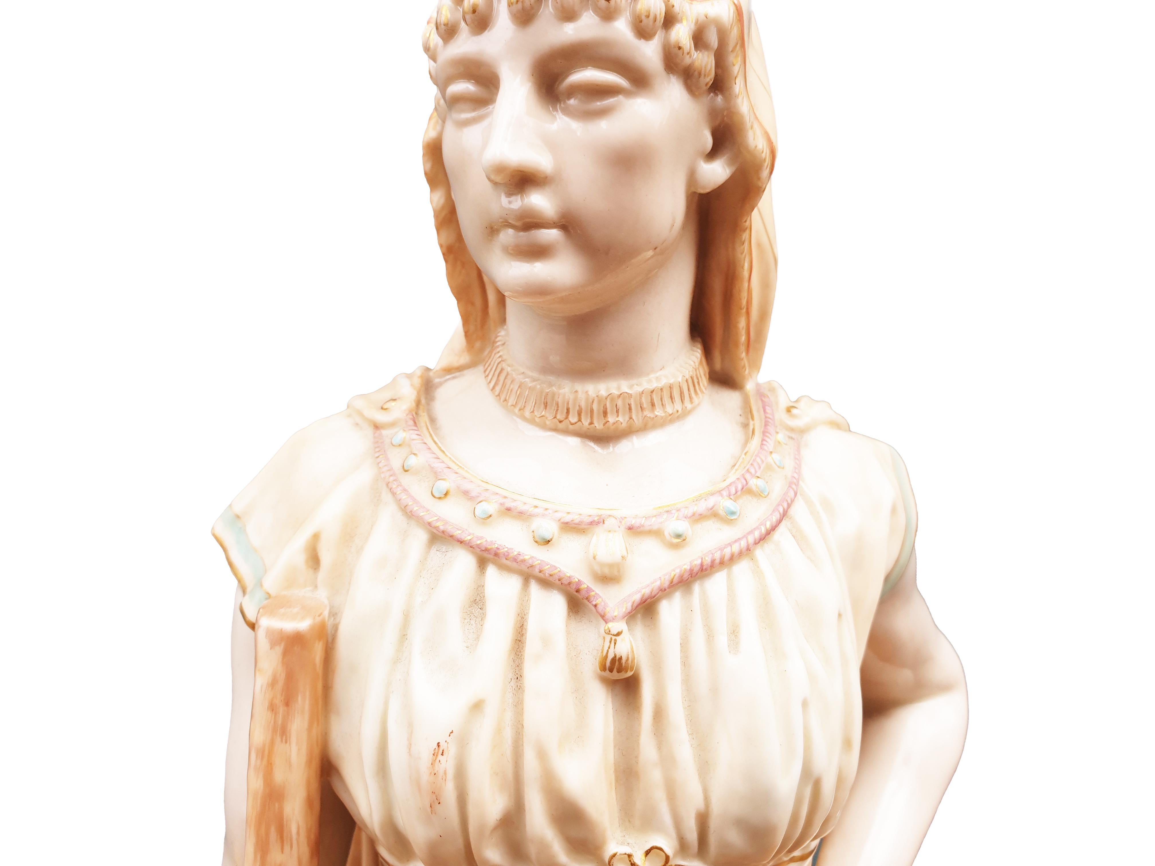 A stunning Signed by James Hadley Royal Worcester Figure Circa 19th century  of a Shepherdess holding a Staff all finished in blush ivory and gilt. Her Victorian Robe held together at the waist with a ribbon band and her neckline is decorated with