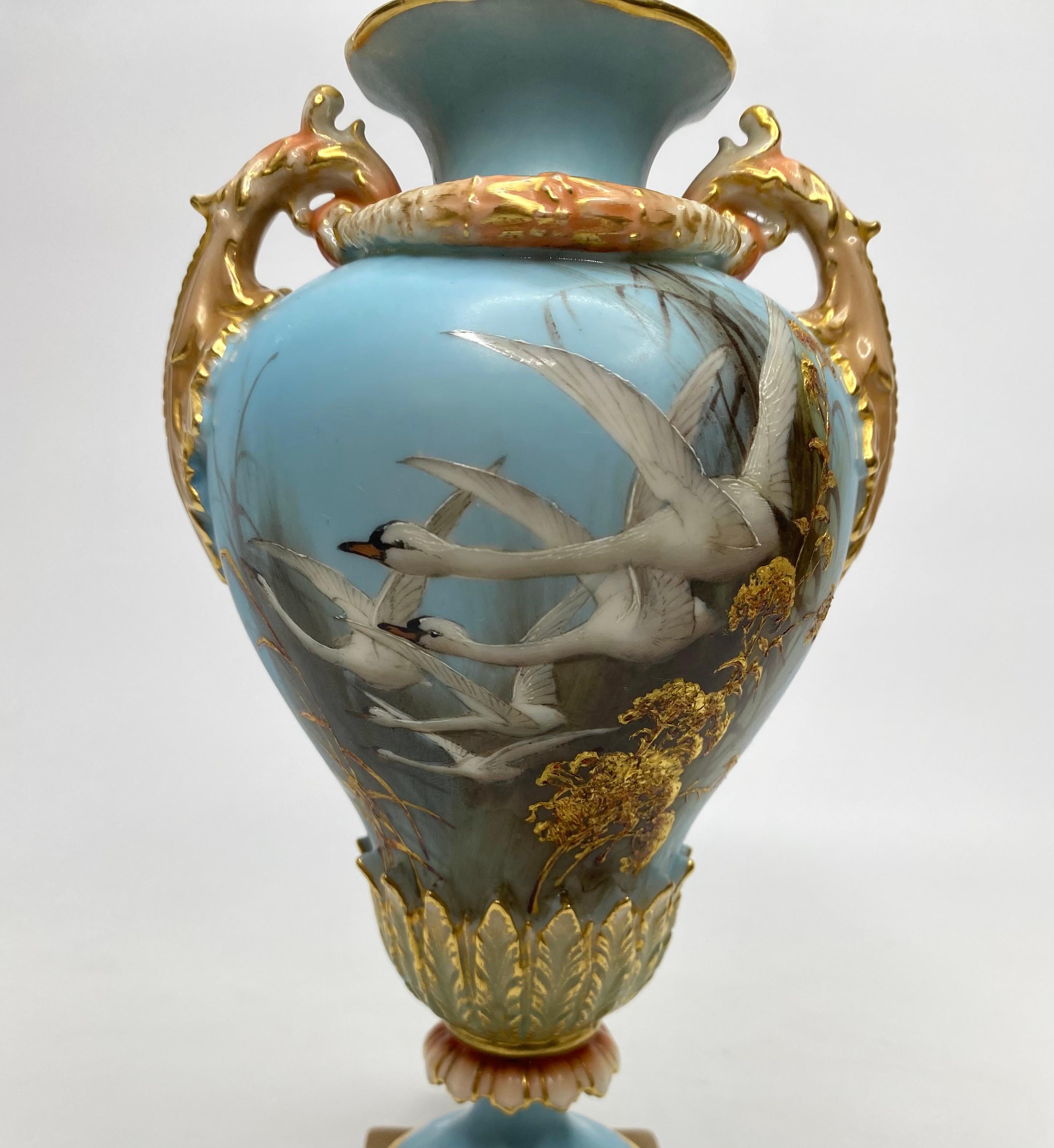 Royal Worcester porcelain vase and cover, painted by Charles H. Baldwyn, dated 1902. Finely painted, with five swans flying amongst reeds, on a sky blue ground. The reverse with a swallow in flight.
The baluster shaped vase, having elaborate gilt