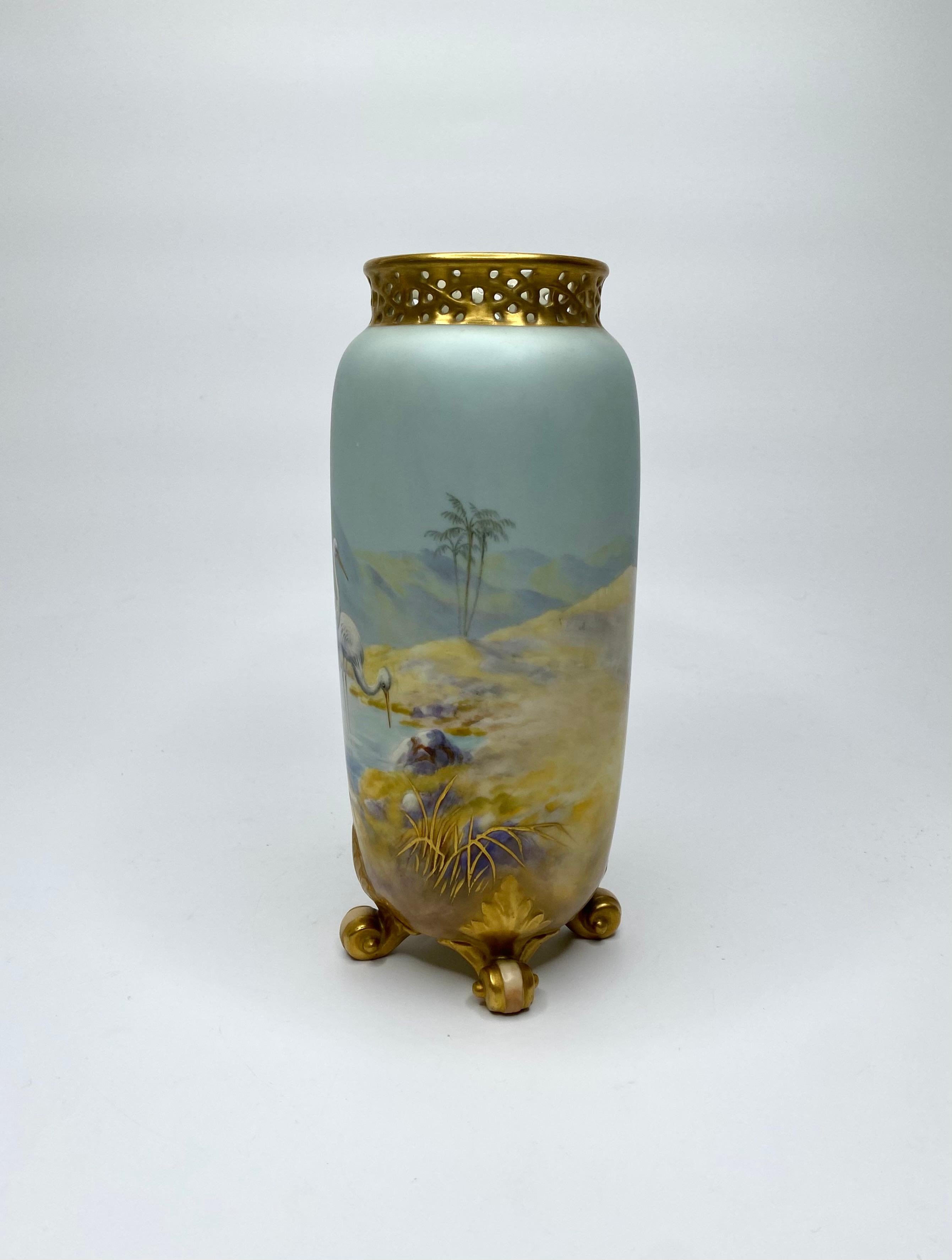 Vase en porcelaine Royal Worcester, Cigognes, peint par George Johnson, daté de 1919. Le corps cylindrique, finement peint, présente une étude de cigognes, dans une oasis, dans un paysage désertique continu.
Le dos est réticulé et doré, et le tout