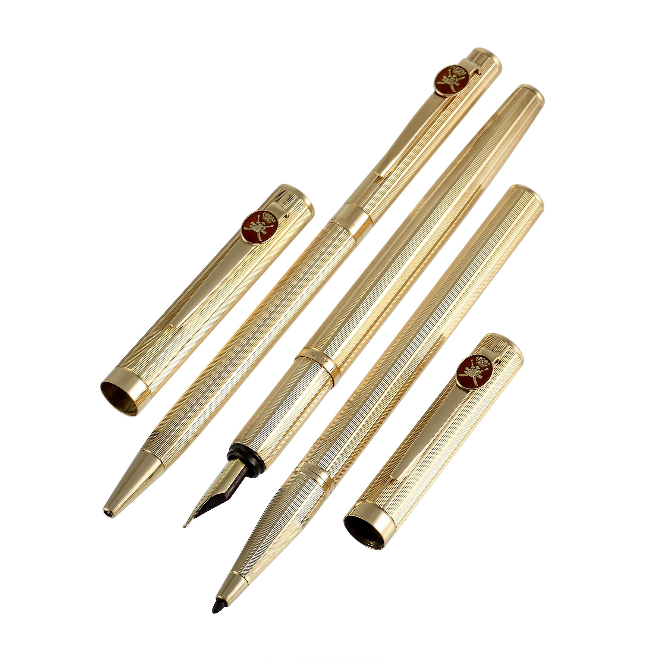 This gorgeous set of three 18K textured yellow gold pens were made by Royama and gifted by the Sultan of Oman. Each pen features the Khanjar, the national emblem of Oman, against a red enamel background. One pen features a fountain tip, one is a