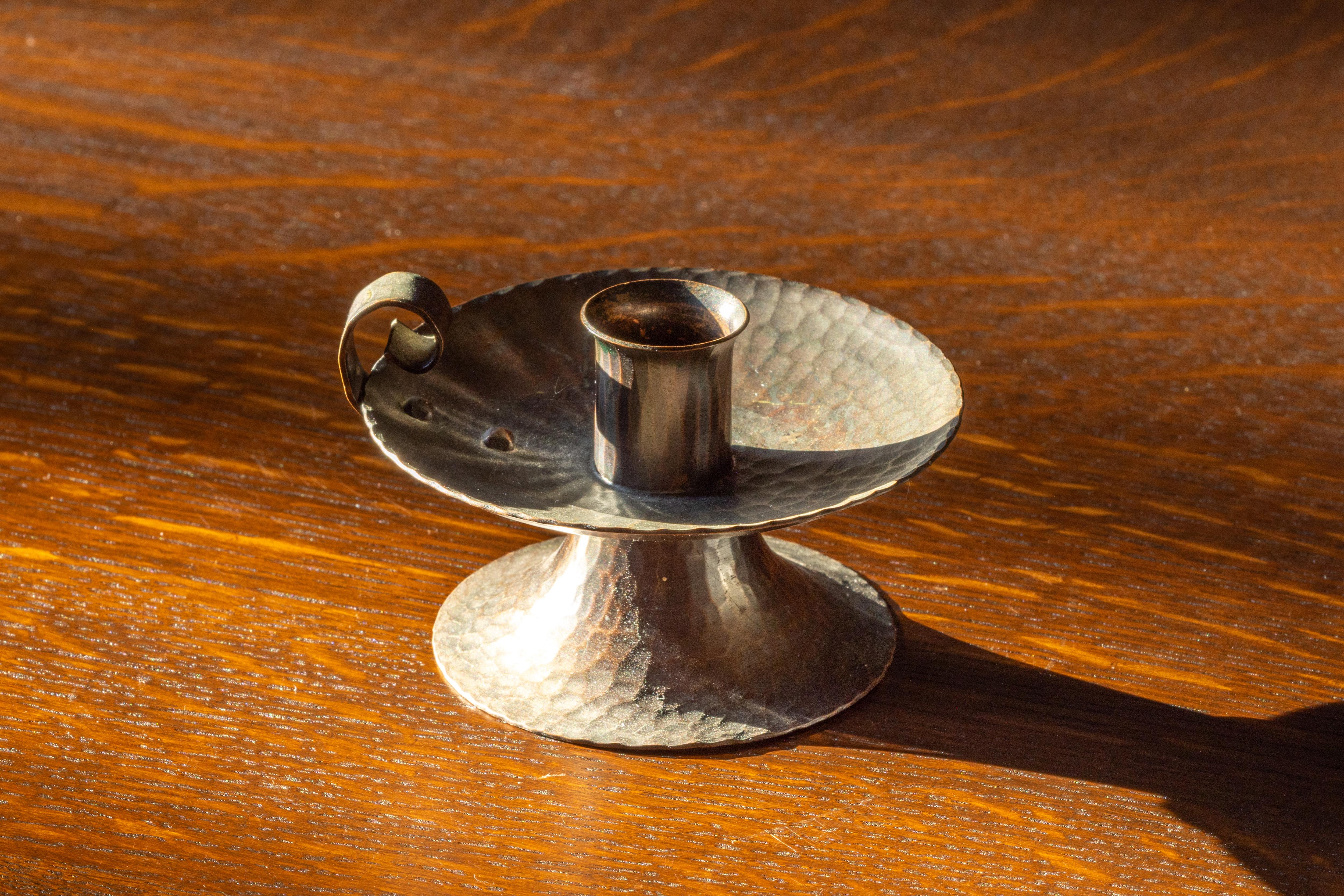 This lovely hammered copper candlestick by Roycroft, the famed American Arts & Crafts workshop, was likely made in the 1920s and bears the Roycroft mark stamped into the underside. With a rich, beautiful patina, this candlestick is highly