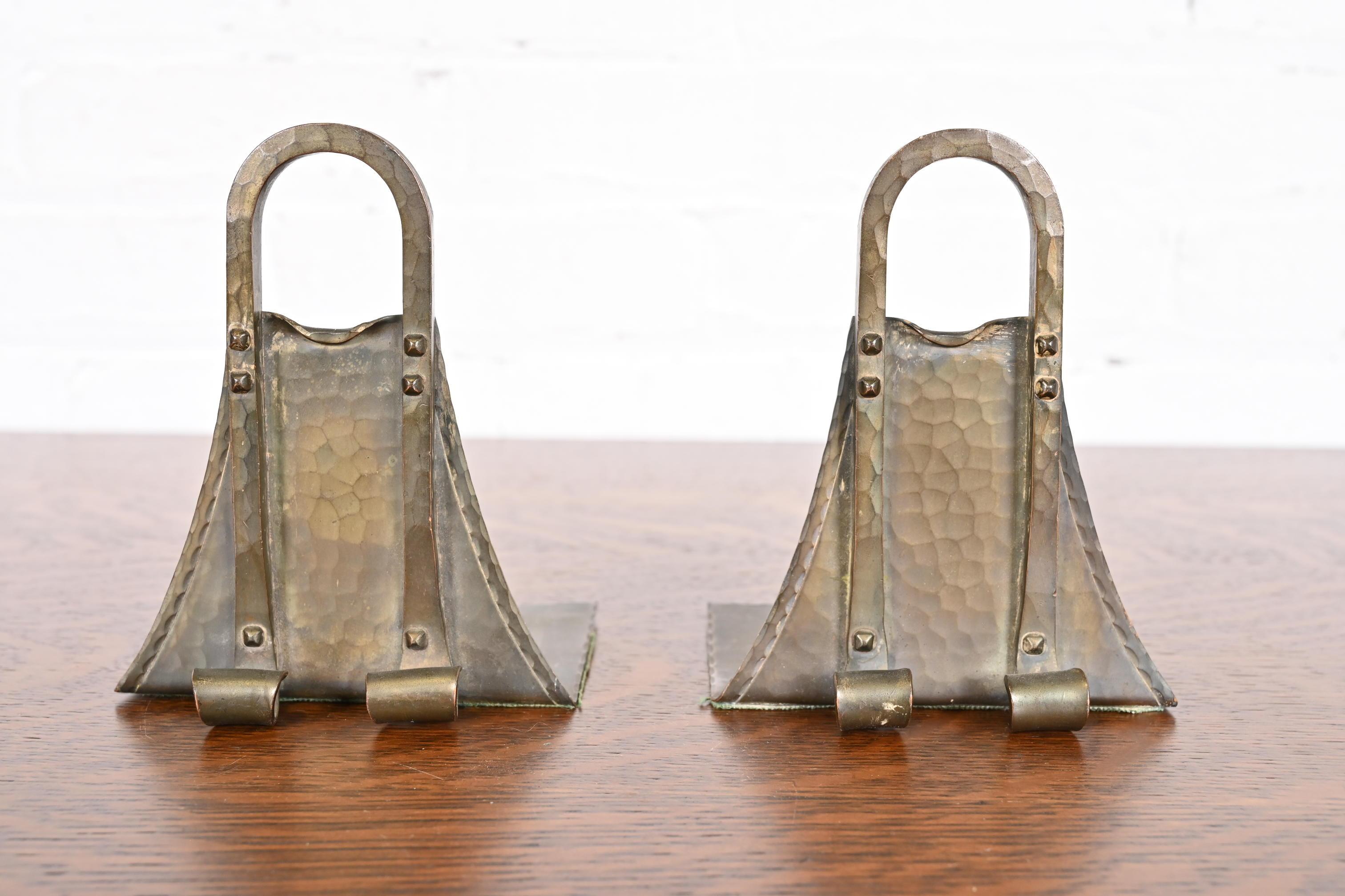 A gorgeous pair of Arts & Crafts period brass finished hand hammered copper bookends

By Roycroft (signed with impressed orb and cross mark)

USA, Early 20th Century

Each measures: 4