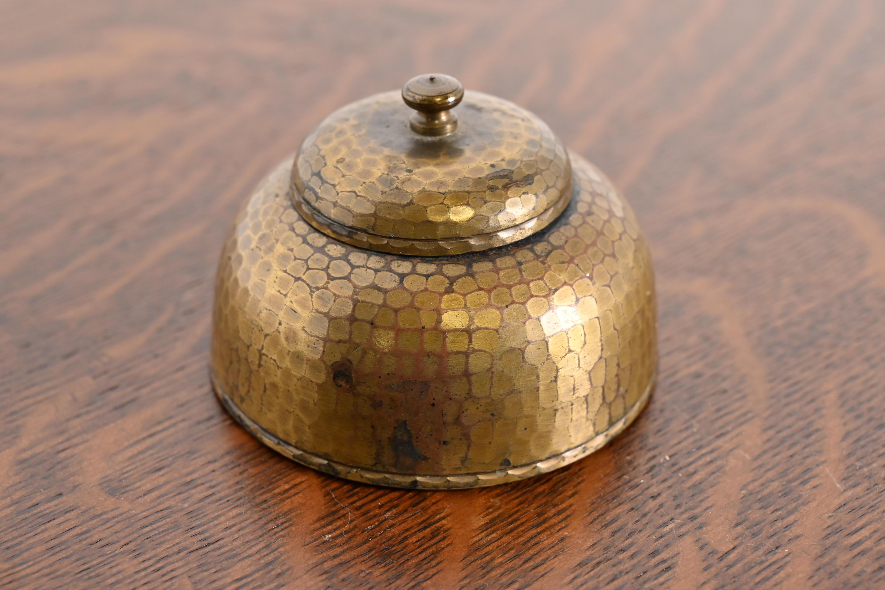 Magnifique encrier en cuivre martelé d'époque Arts & Crafts, fini laiton.

Par Roycroft (signé avec un orbe imprimé et une marque de croix)

États-Unis d'Amérique, début du 20e siècle

Dimensions : 3,25 