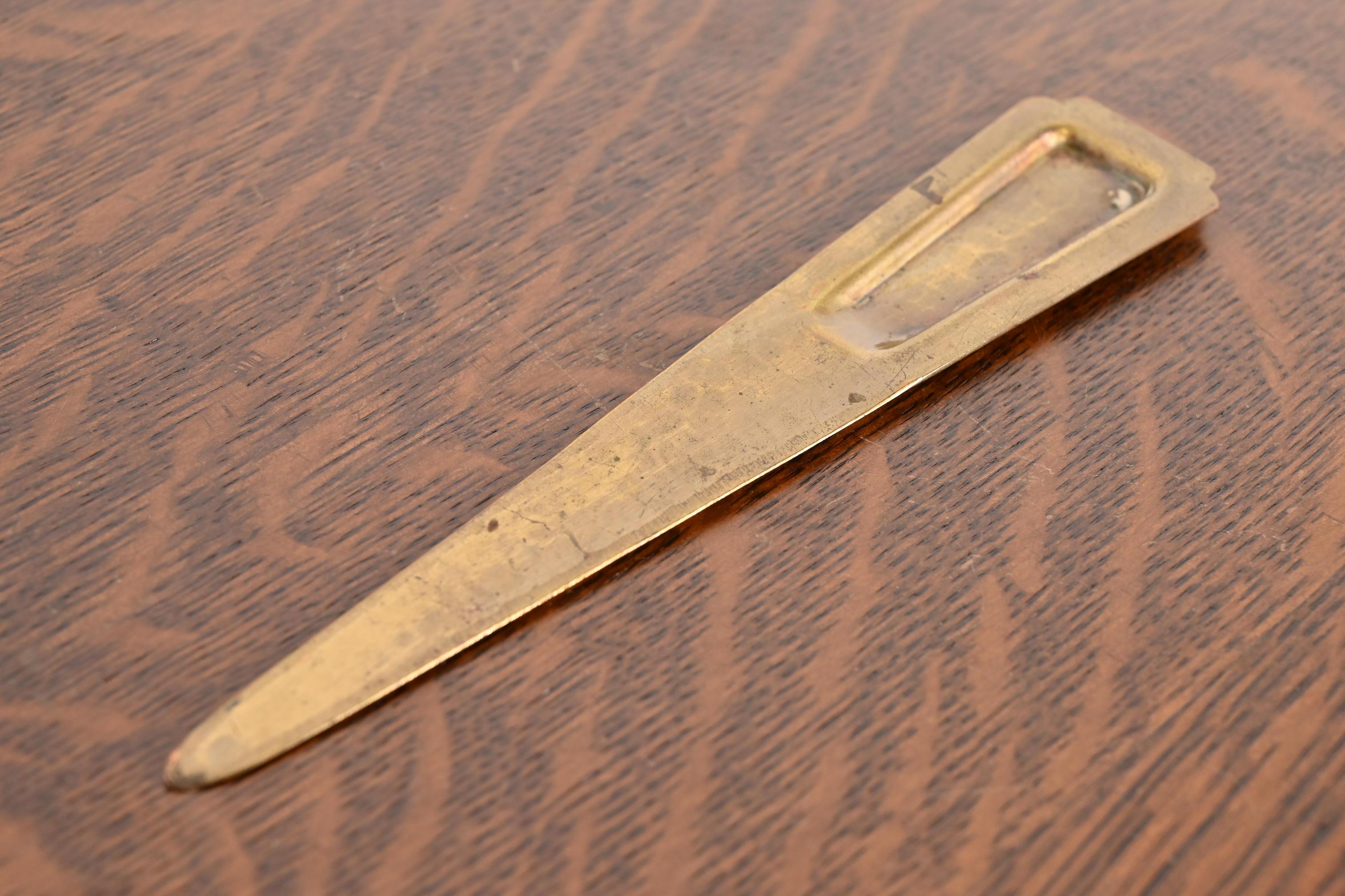 Un magnifique coupe-papier en cuivre martelé d'époque Arts & Crafts, fini laiton.

Par Roycroft (signé avec un orbe imprimé et une marque de croix)

États-Unis d'Amérique, début du 20e siècle

Dimensions : 7,75 