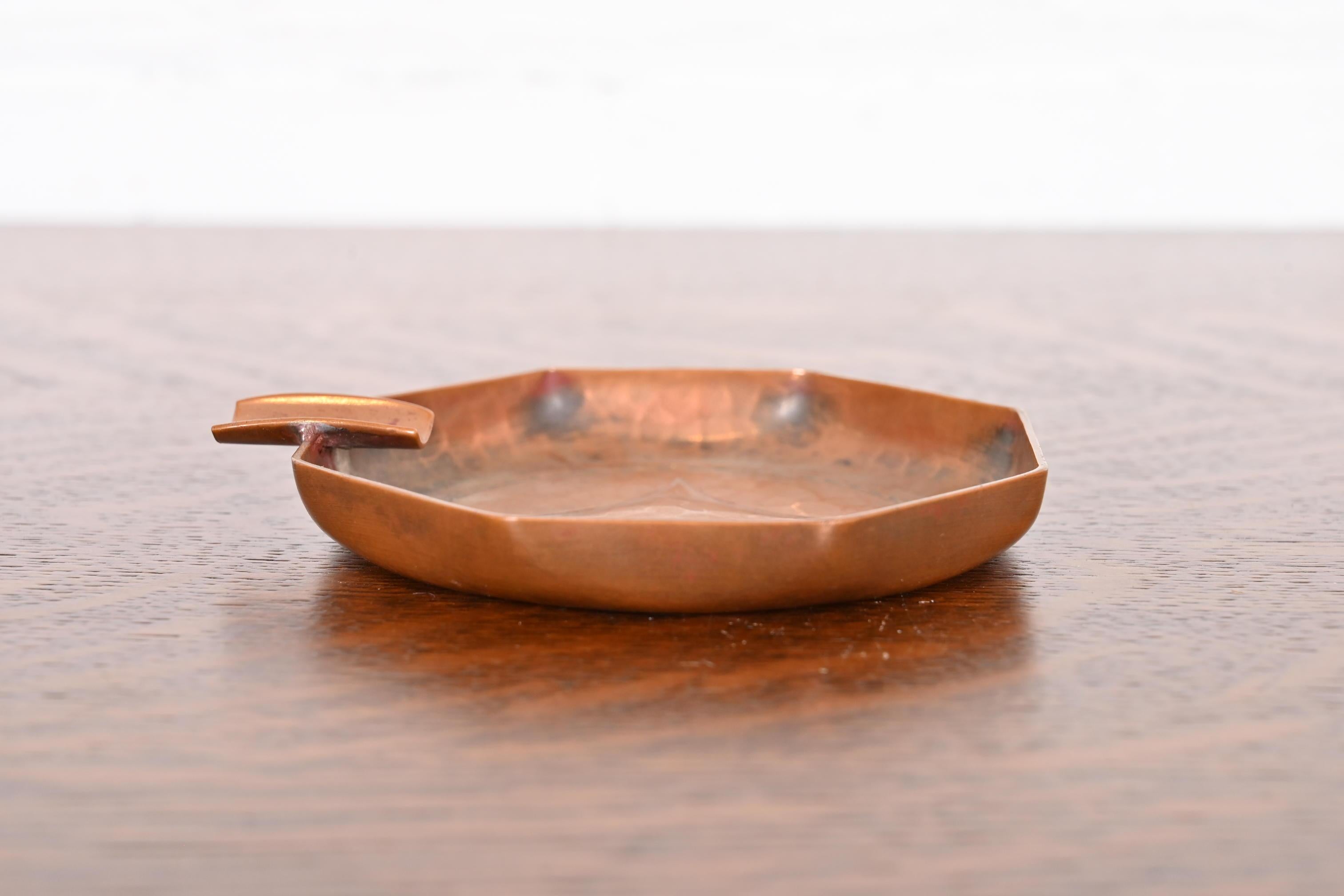 Uno splendido posacenere in rame martellato a mano del periodo Arts & Crafts

Di Roycroft (firmato con orbita impressa e marchio a croce)

Stati Uniti, inizio del XX secolo

Ciascuna misura: 4,5
