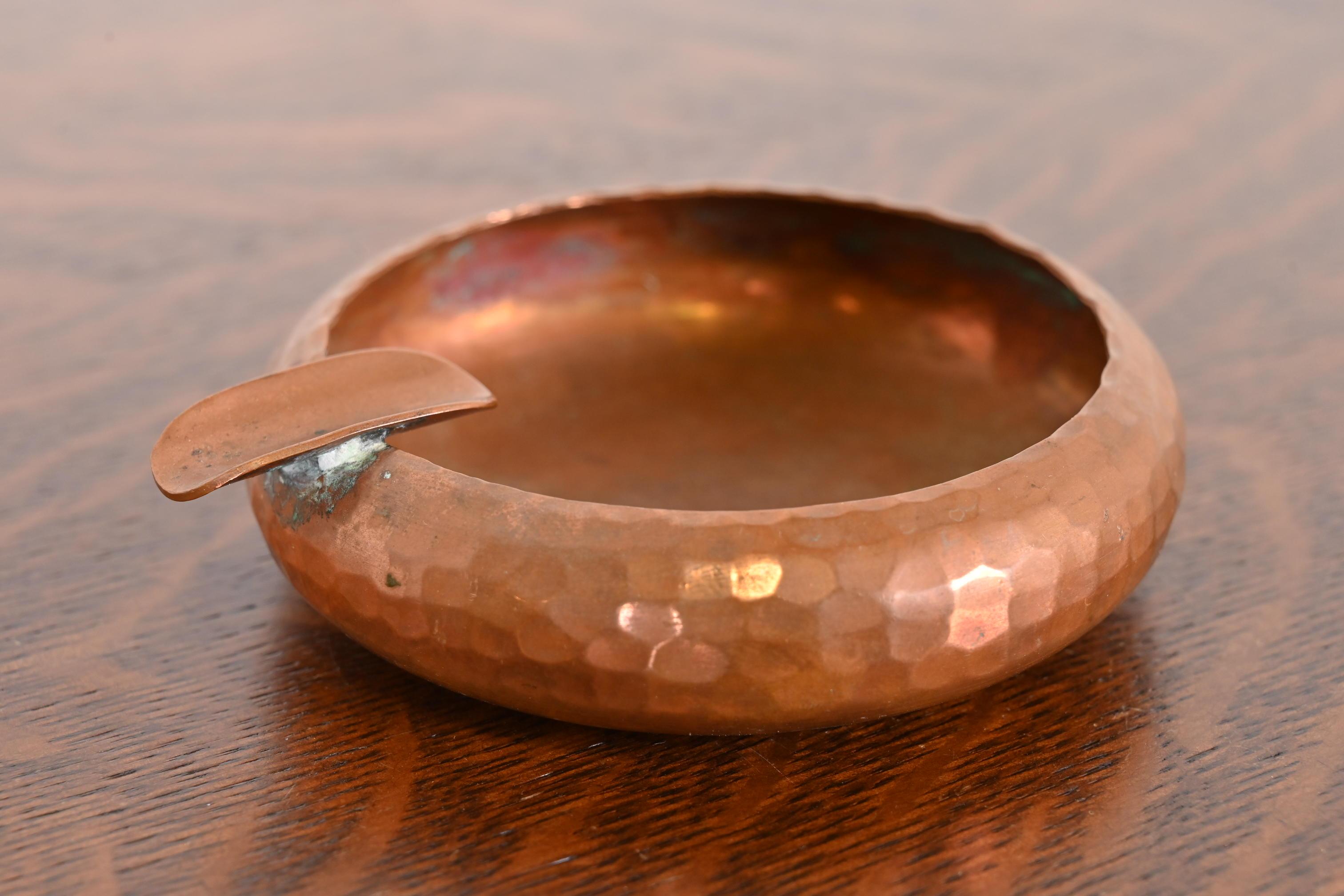 Precioso cenicero de cobre martillado a mano de la época Arts & Crafts

Por Roycroft (firmado con orbe impreso y marca de cruz)

EE.UU., principios del siglo XX

Medidas: 4,75