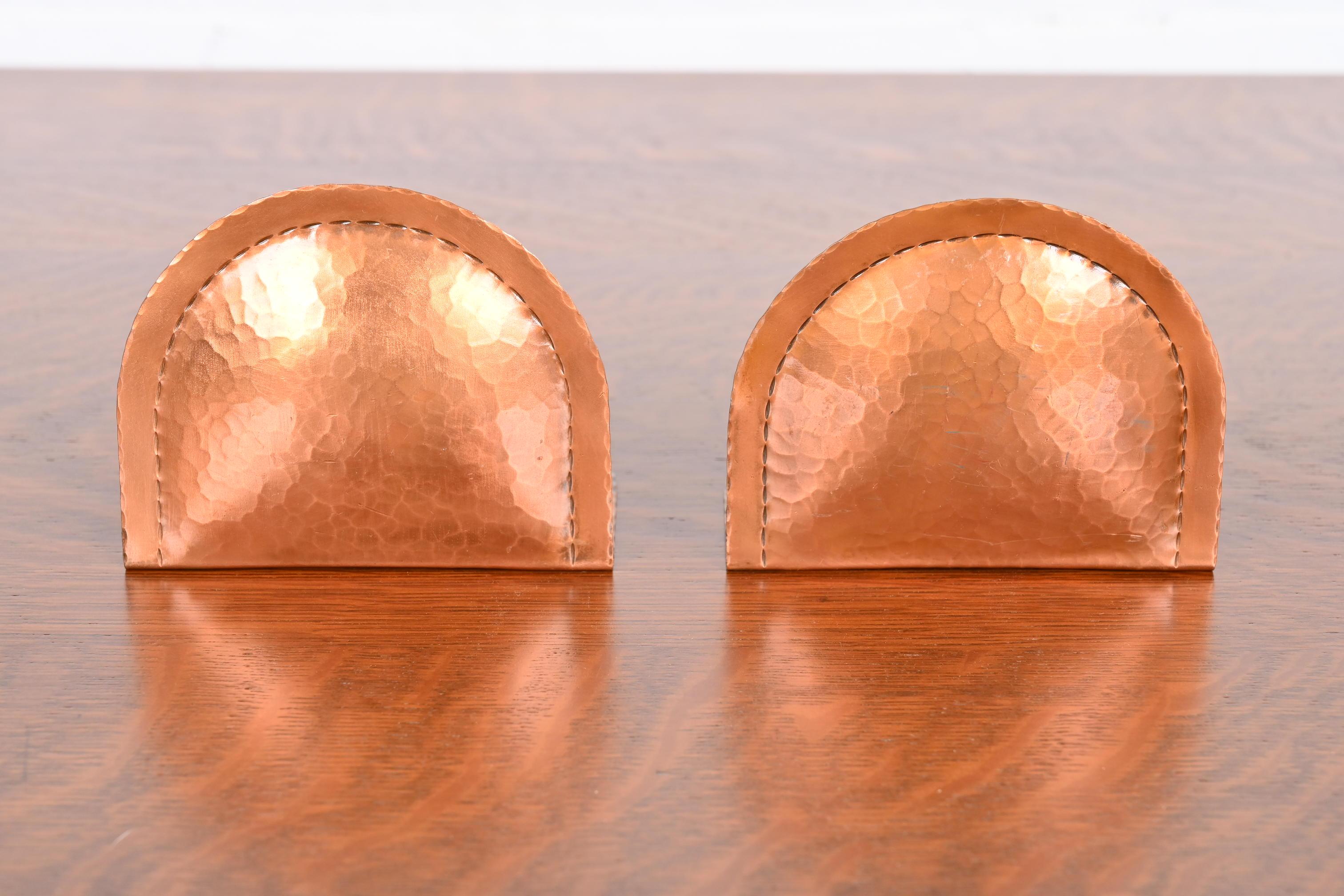 A gorgeous pair of Arts & Crafts period hand-hammered copper bookends.

By Roycroft (signed with impressed orb and cross mark)

USA, early 20th century.

Each measures: 4.25