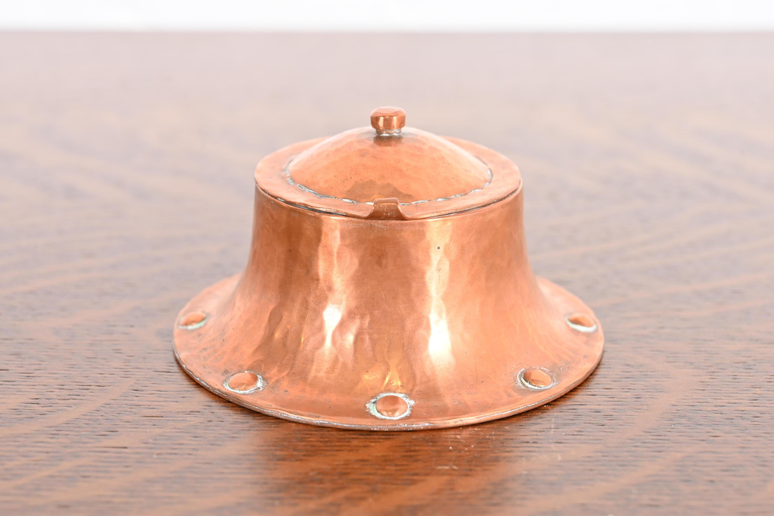 A gorgeous Arts & Crafts period hand hammered copper inkwell.

By Roycroft (signed with impressed orb and cross mark)

USA, Early 20th Century

Each measures: 4