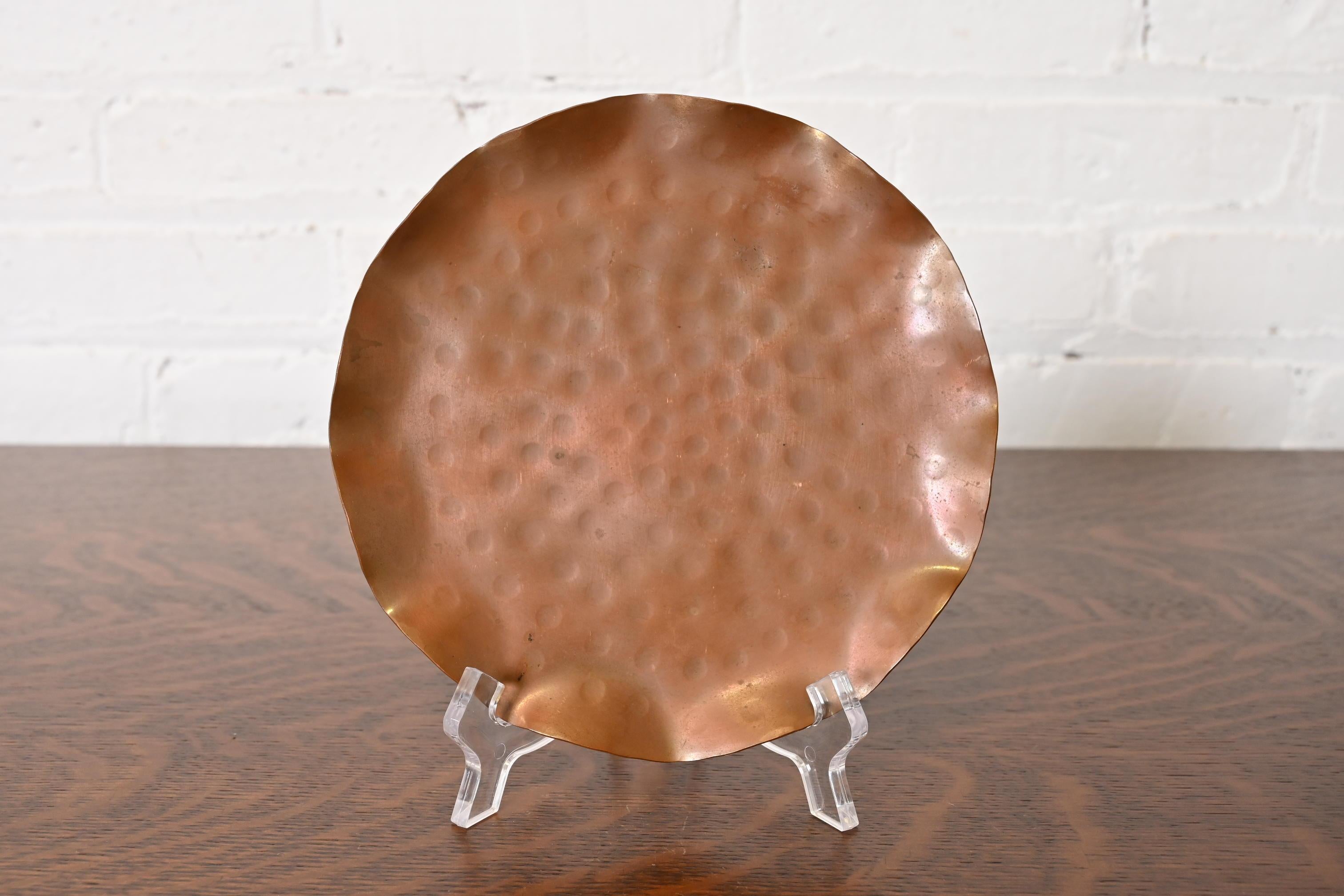 Uno splendido piatto o cestino in rame martellato a mano del periodo Arts & Crafts con bordo smerlato

Di Roycroft (firmato con orbita impressa e marchio a croce)

Stati Uniti, inizio del XX secolo

Ciascuna misura: 6,75