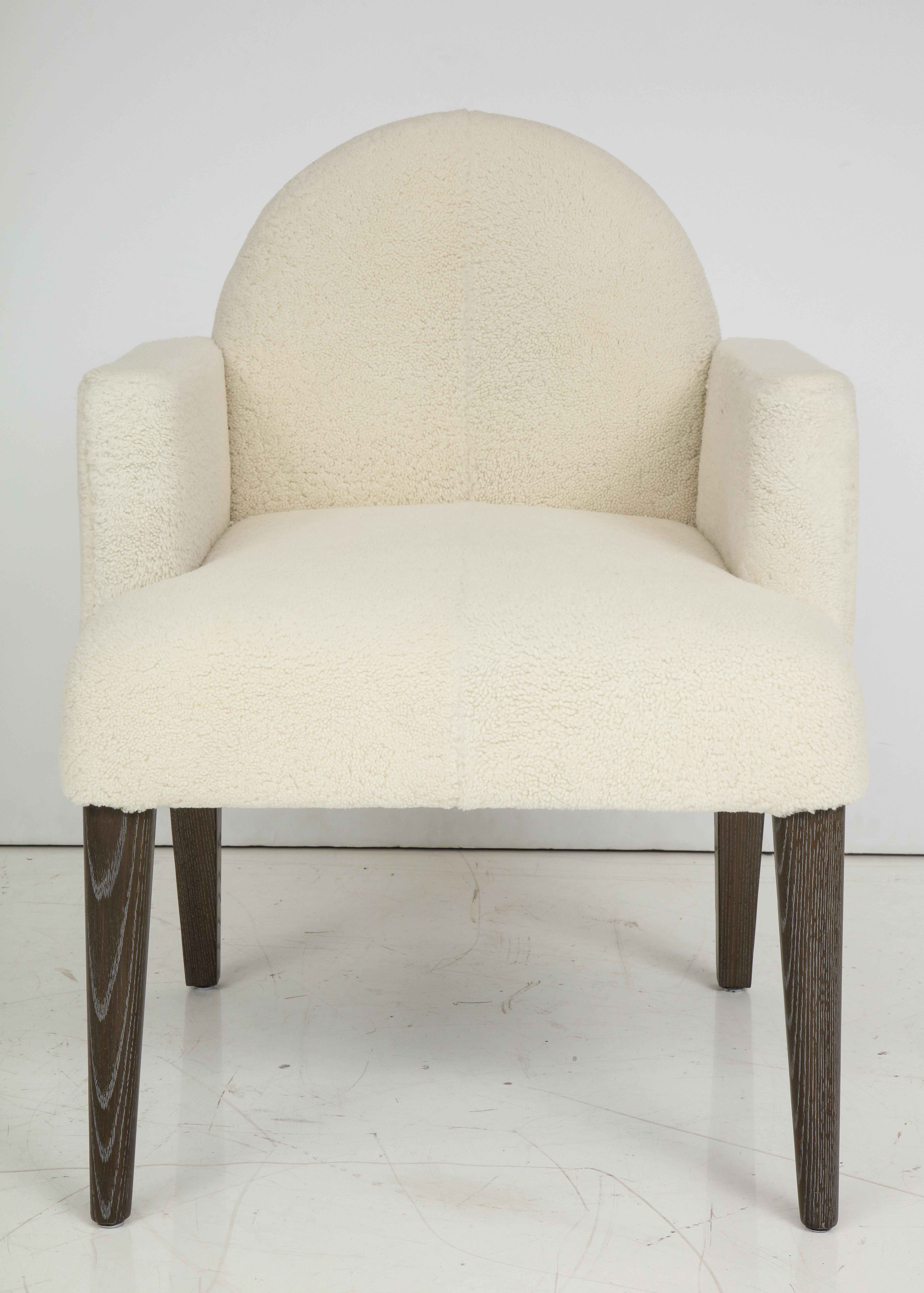 Chic Modernist  pair of armchairs featuring cerused oak tapered legs and new off-white lambswool upholstery. 