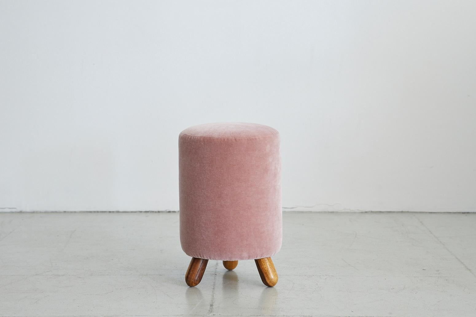 Lovely shaped Royère style stool with 3 wood peg legs. Newly upholstered in pink mohair.