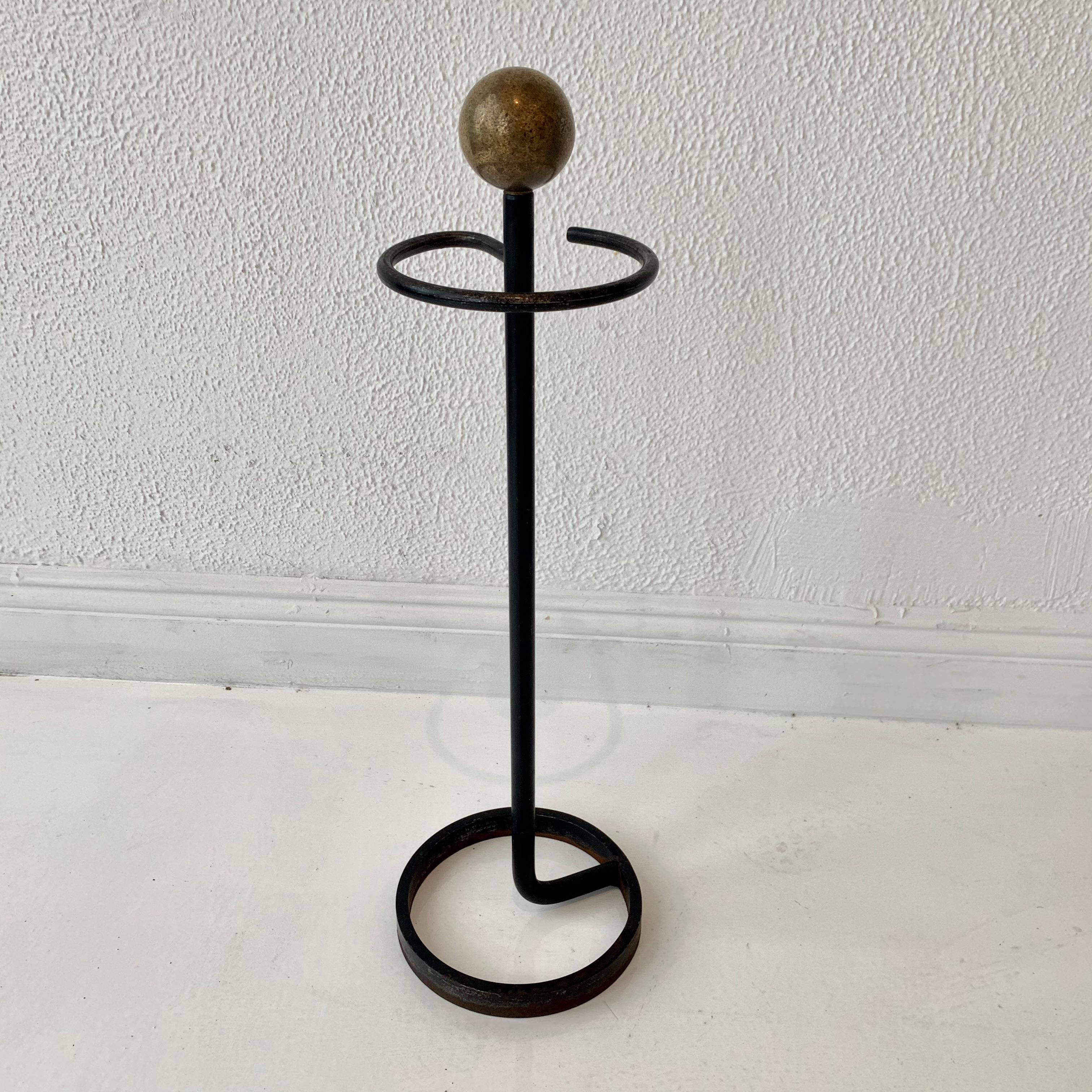Handsome brass and iron umbrella stand. Circular iron base with inset iron pole. Brass ball top. Circular iron ring to hold umbrellas. Excellent patina. Great vintage condition.