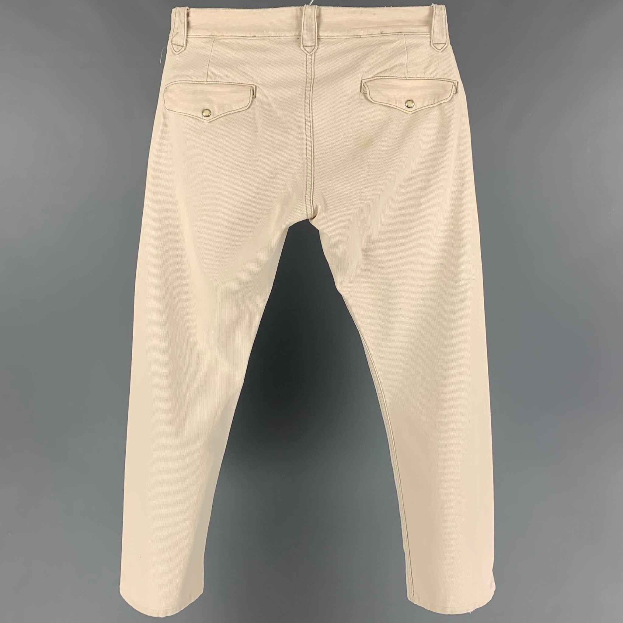 RRL by RALPH LAUREN pants comes in a beige cotton featuring a slim fit, contrast stitching, and a button fly closure. Made in USA.
Good
Pre-Owned Condition. Light discoloration. As-Is.  

Marked:   30/32 

Measurements: 
  Waist: 32 inches  Rise: 10